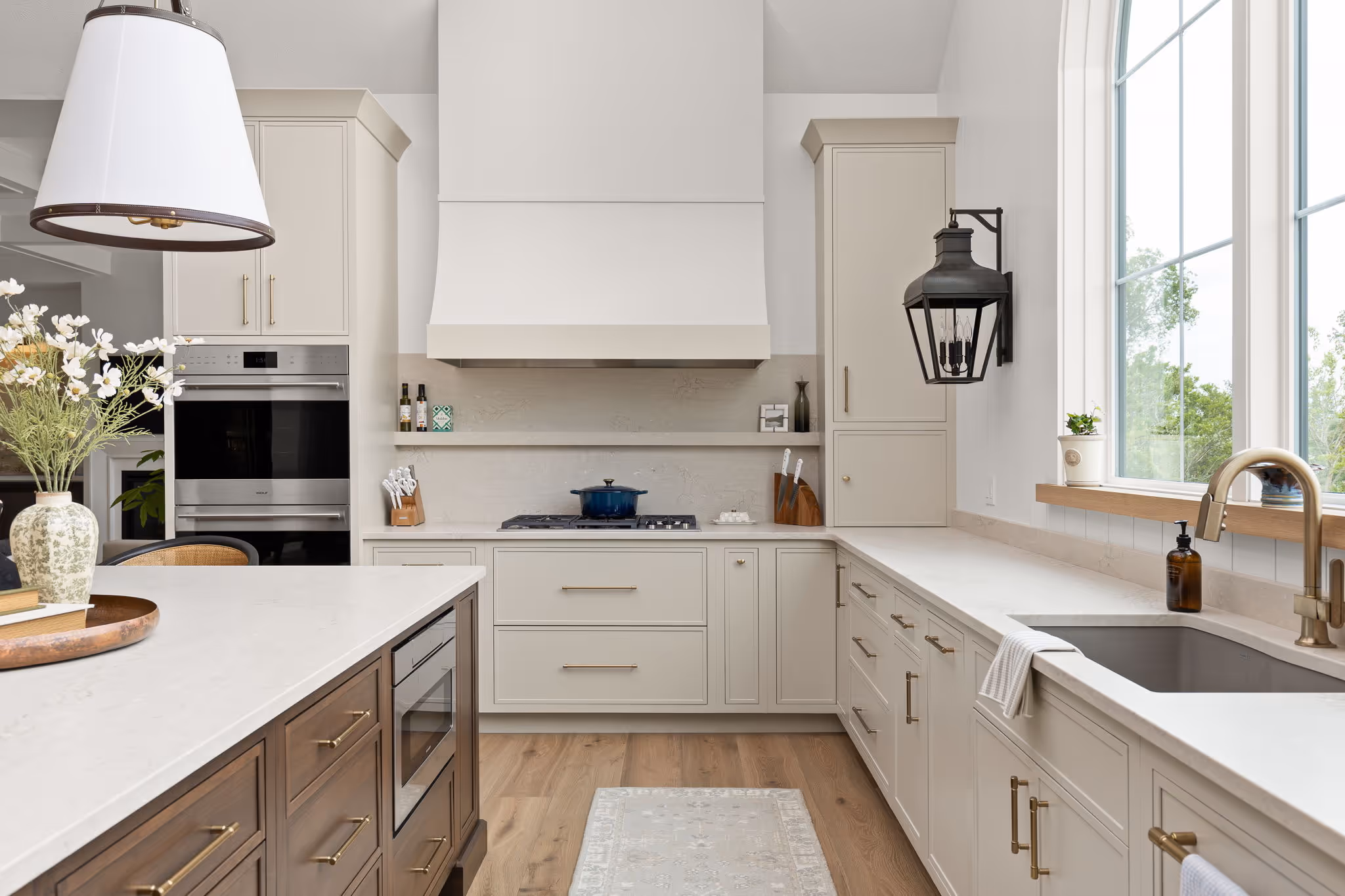 Bright white kitchen with peninsula, sink, and pendant lights