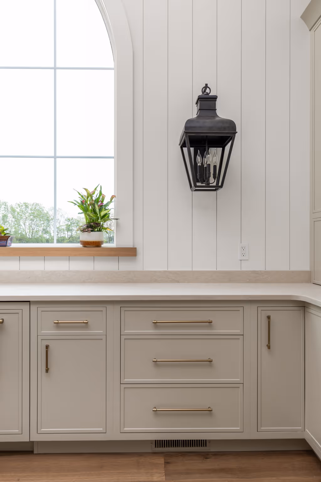 White kitchen cabinets with countertop and wall sconce