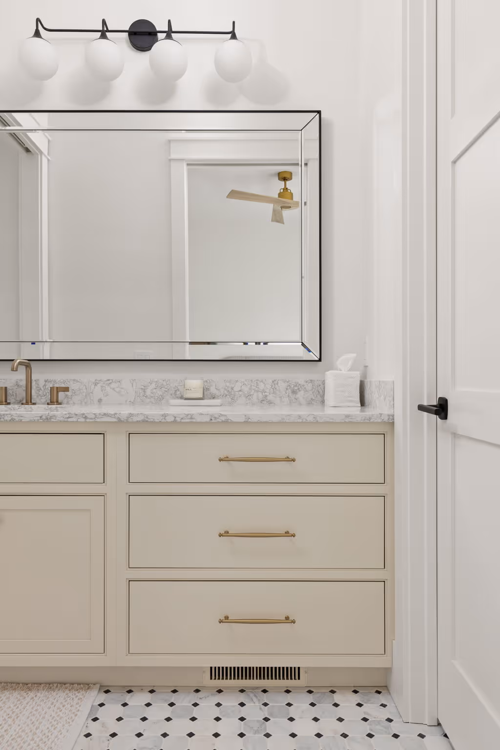 White bathroom vanity with brass fixtures and mirror