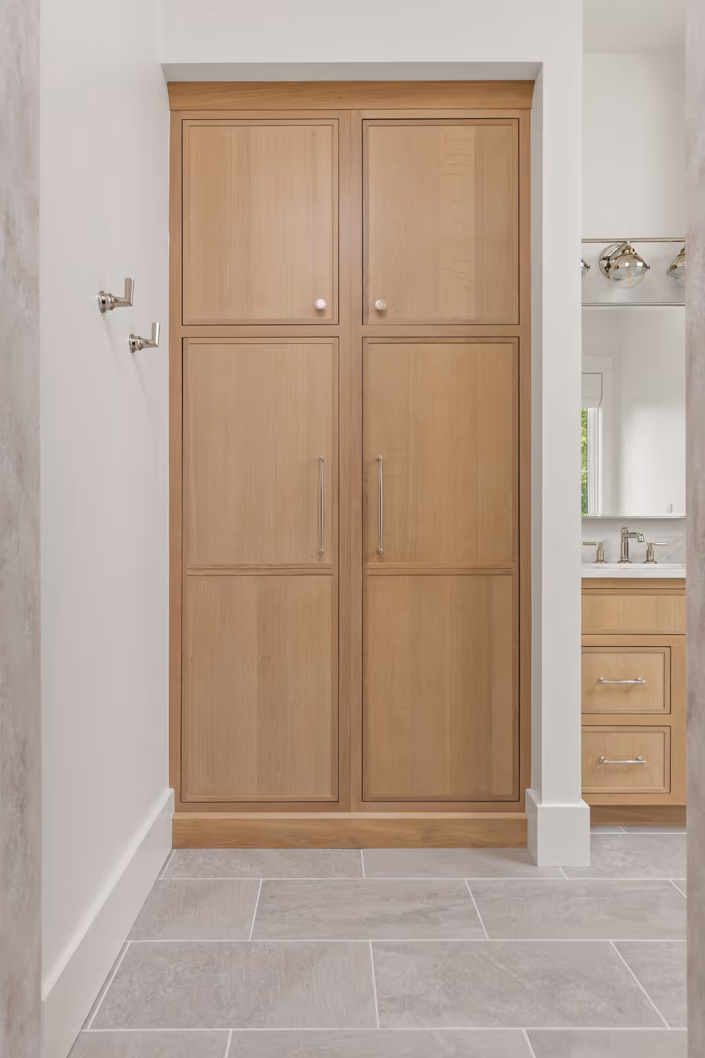 Light wood interior door in white hallway