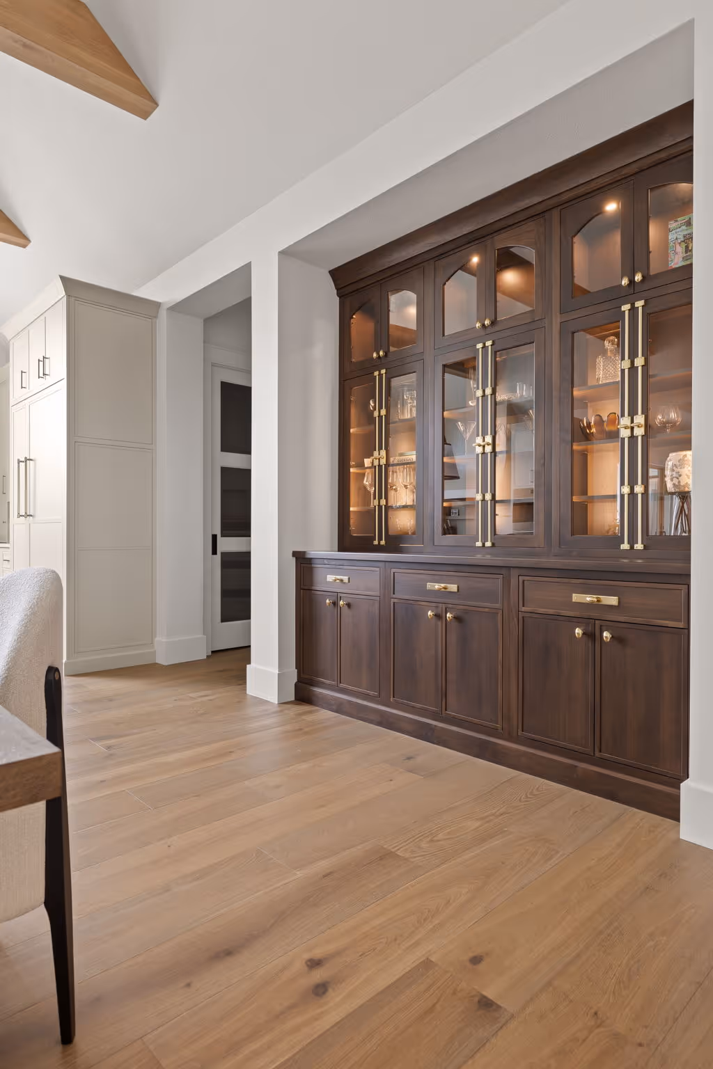 Hallway with dark built-in cabinets and glass-front shelving
