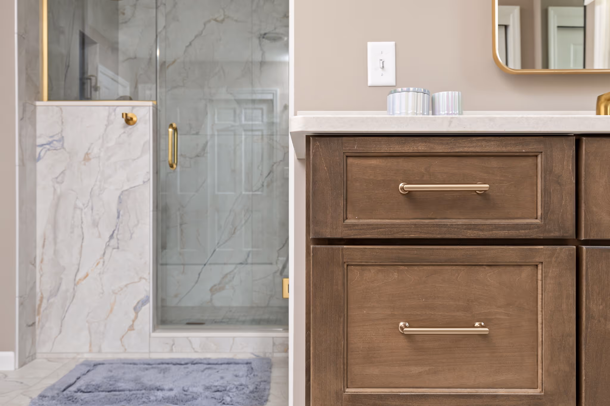 Marble shower with glass door and brass fixtures