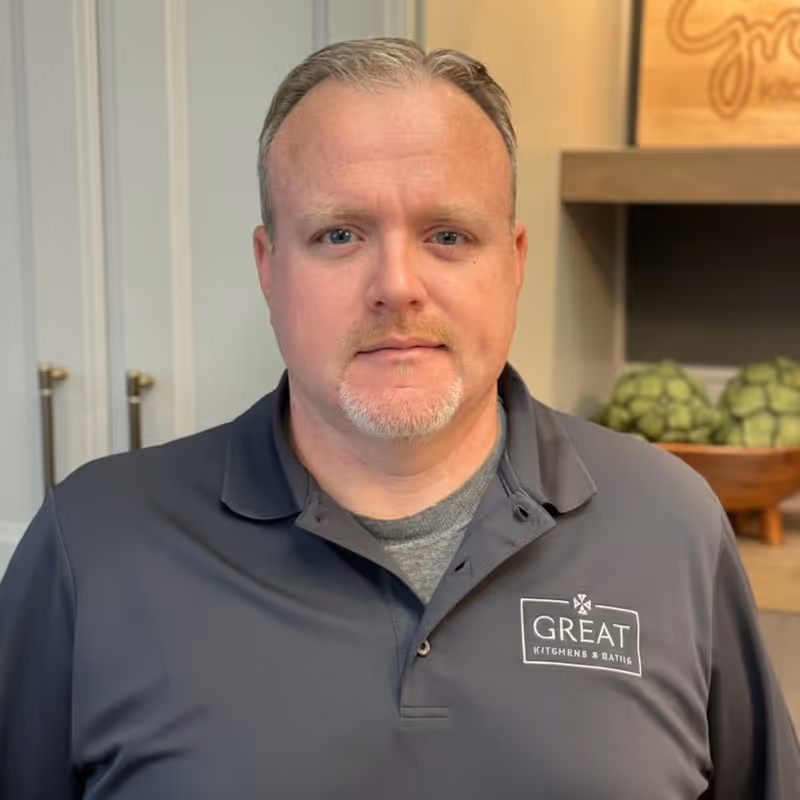Professional headshot of man in gray polo shirt