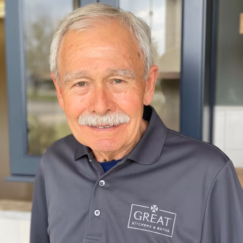 Professional headshot of older man in blue shirt