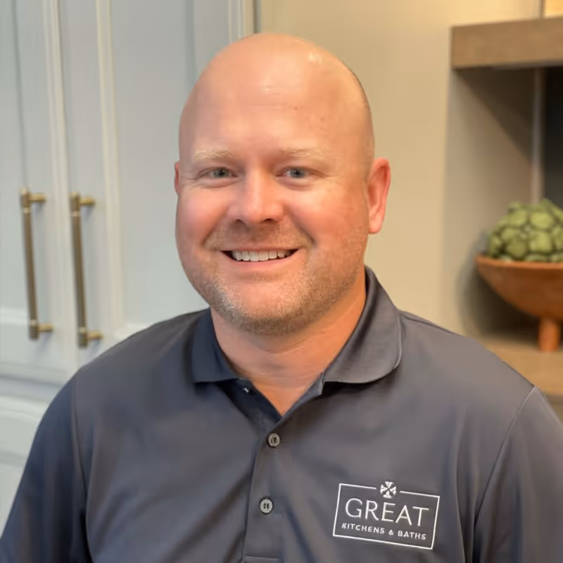 Professional headshot of smiling man in dark shirt