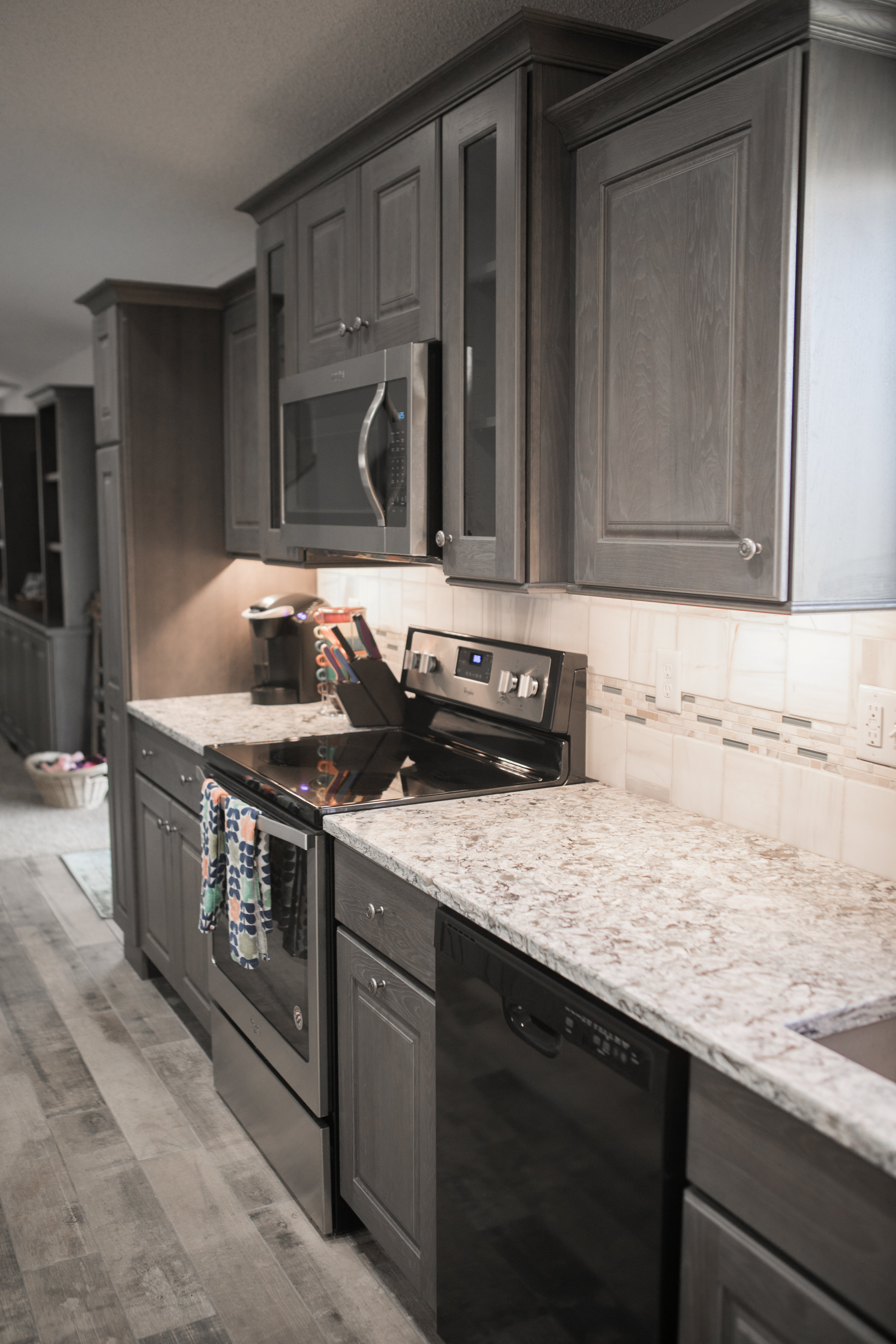Modern kitchen with gray cabinets and marble countertop.