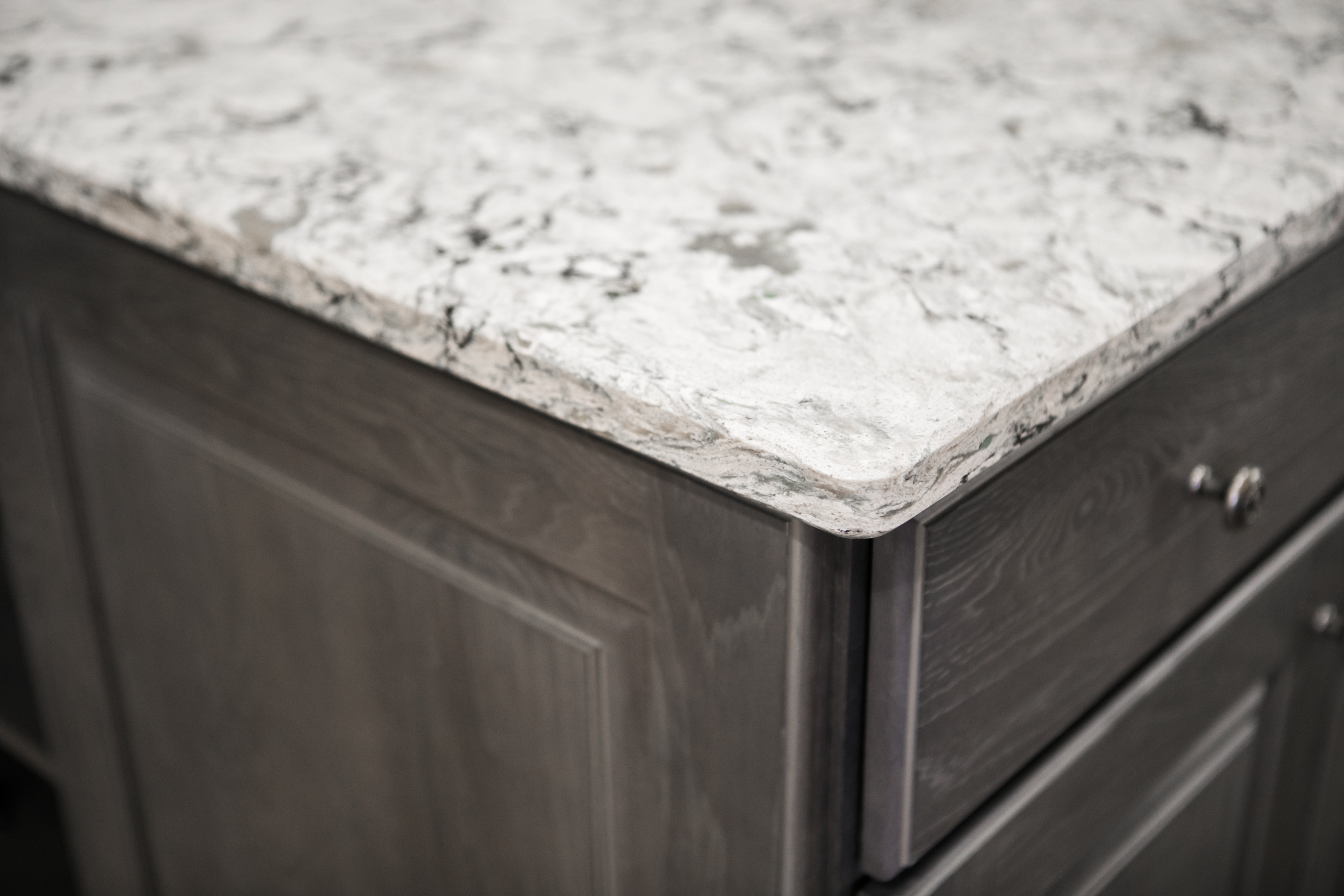 Close-up of marble countertop on dark cabinetry.