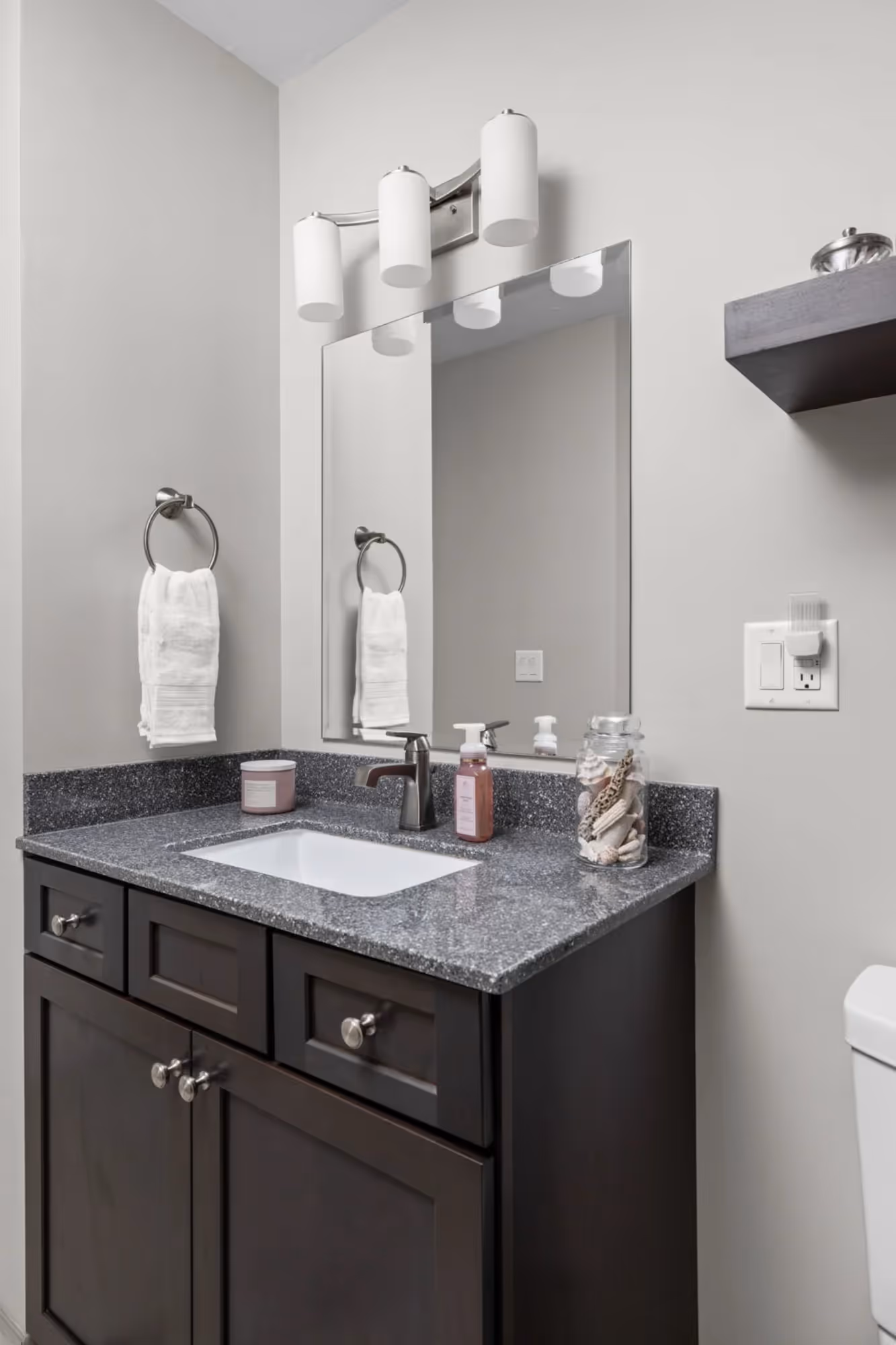 Bathroom vanity with dark cabinets and patterned tile floor