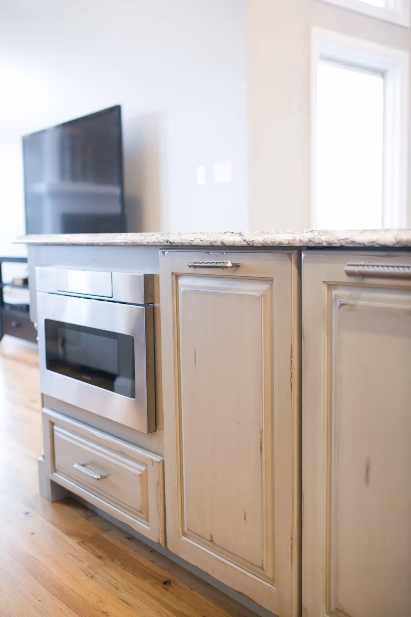 Stainless steel refrigerator beside light wood cabinetry