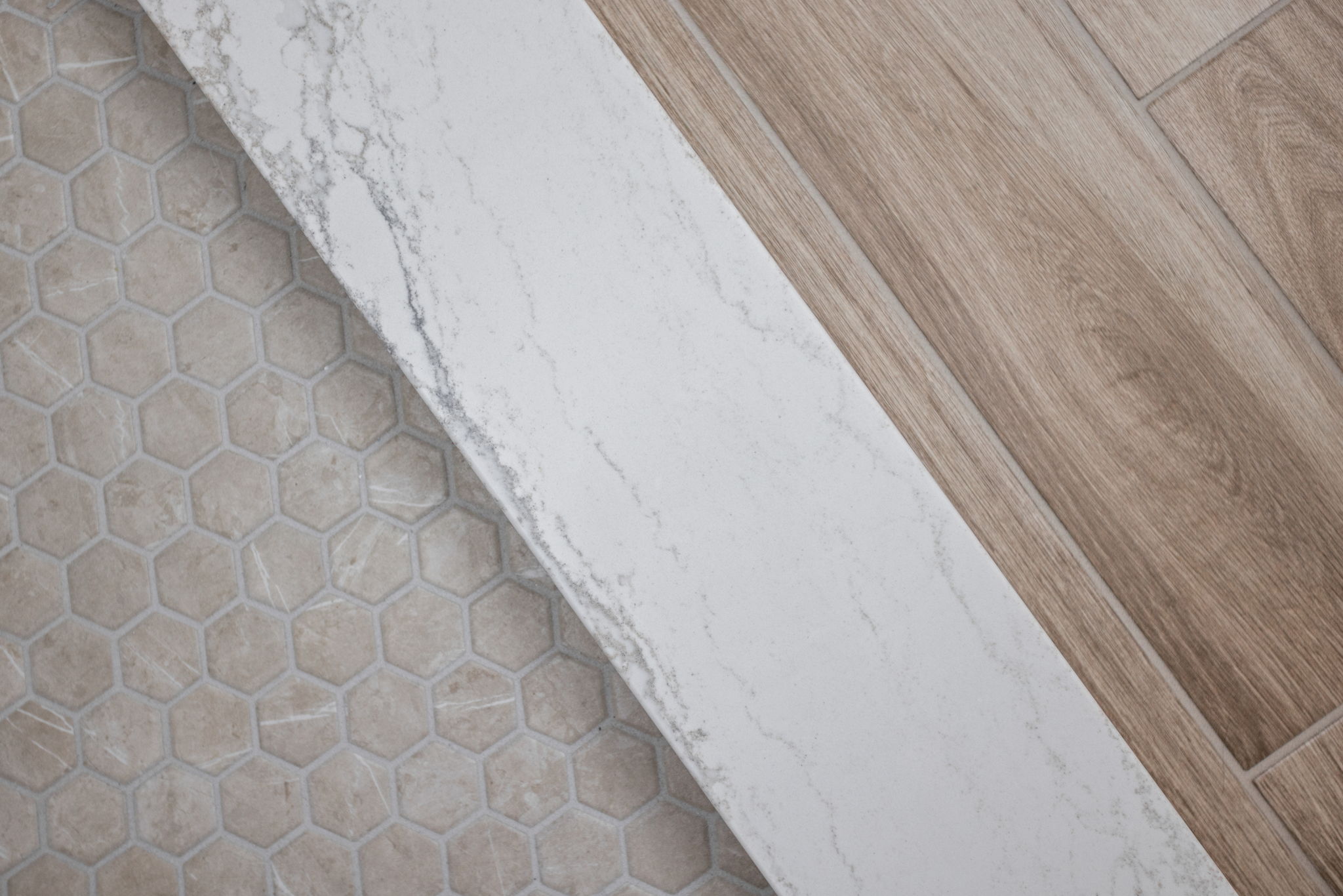 Bathroom floor with hex tile and wood threshold