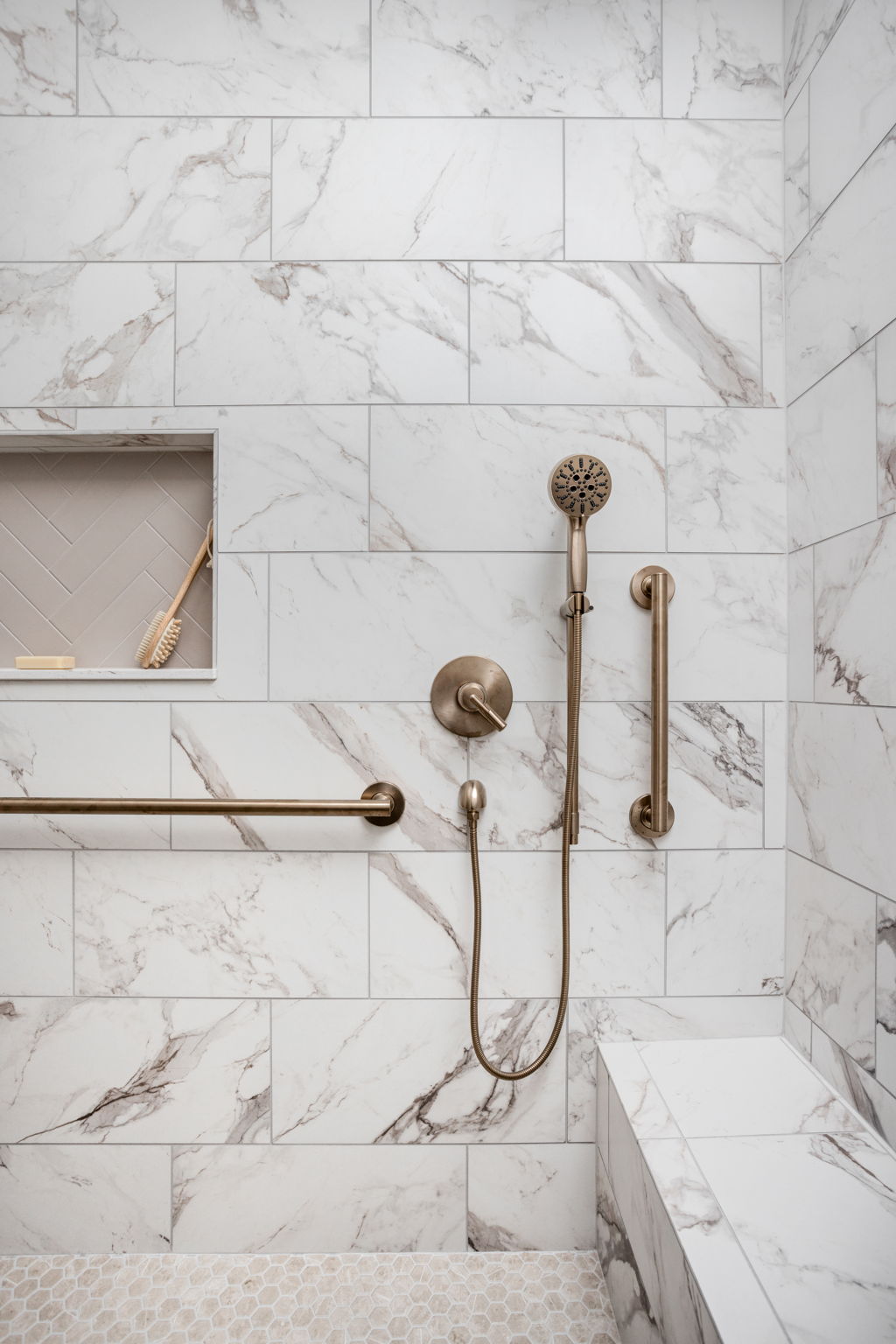 Brass showerhead and hand shower on marble wall