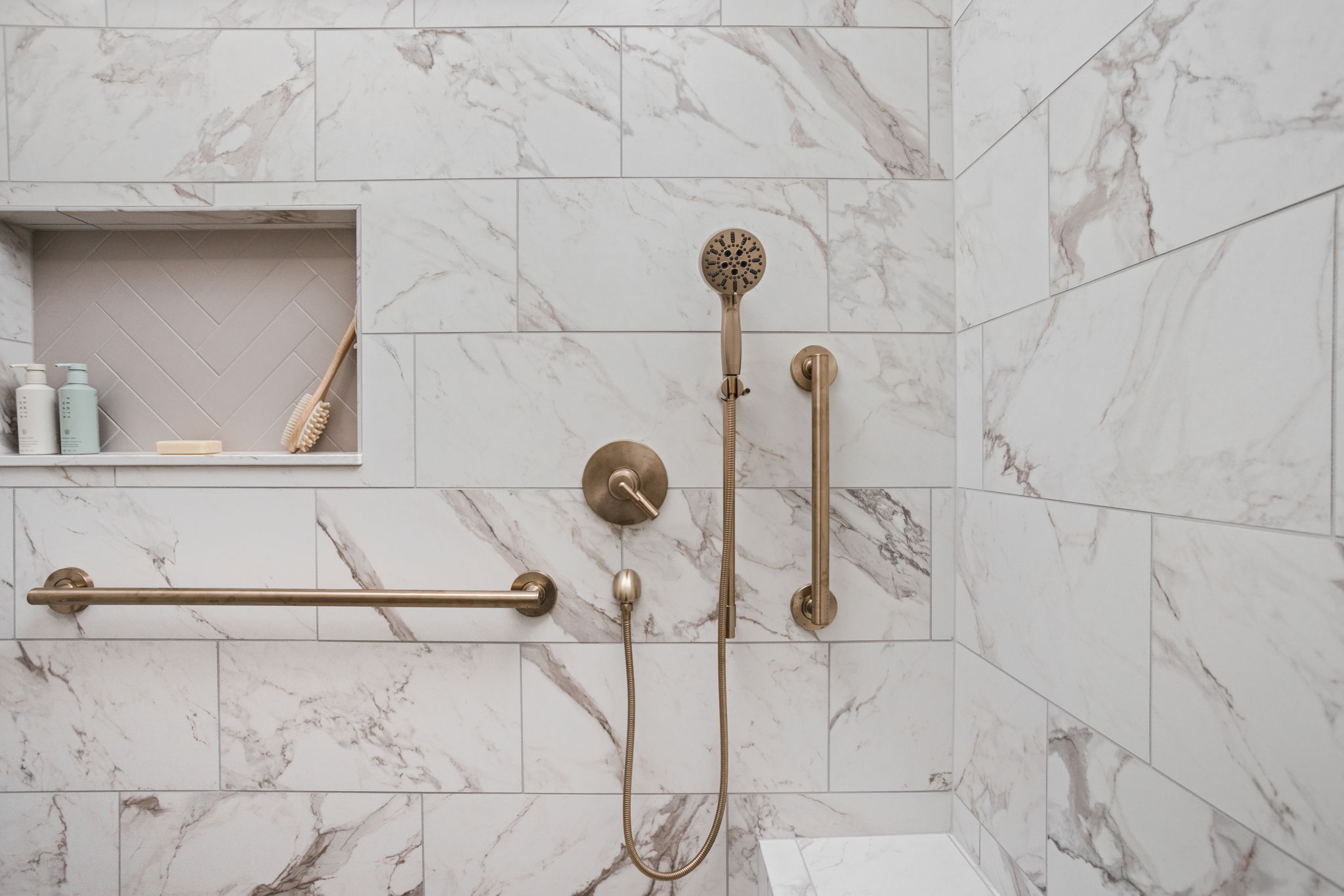Marble shower wall with brass shower fixtures