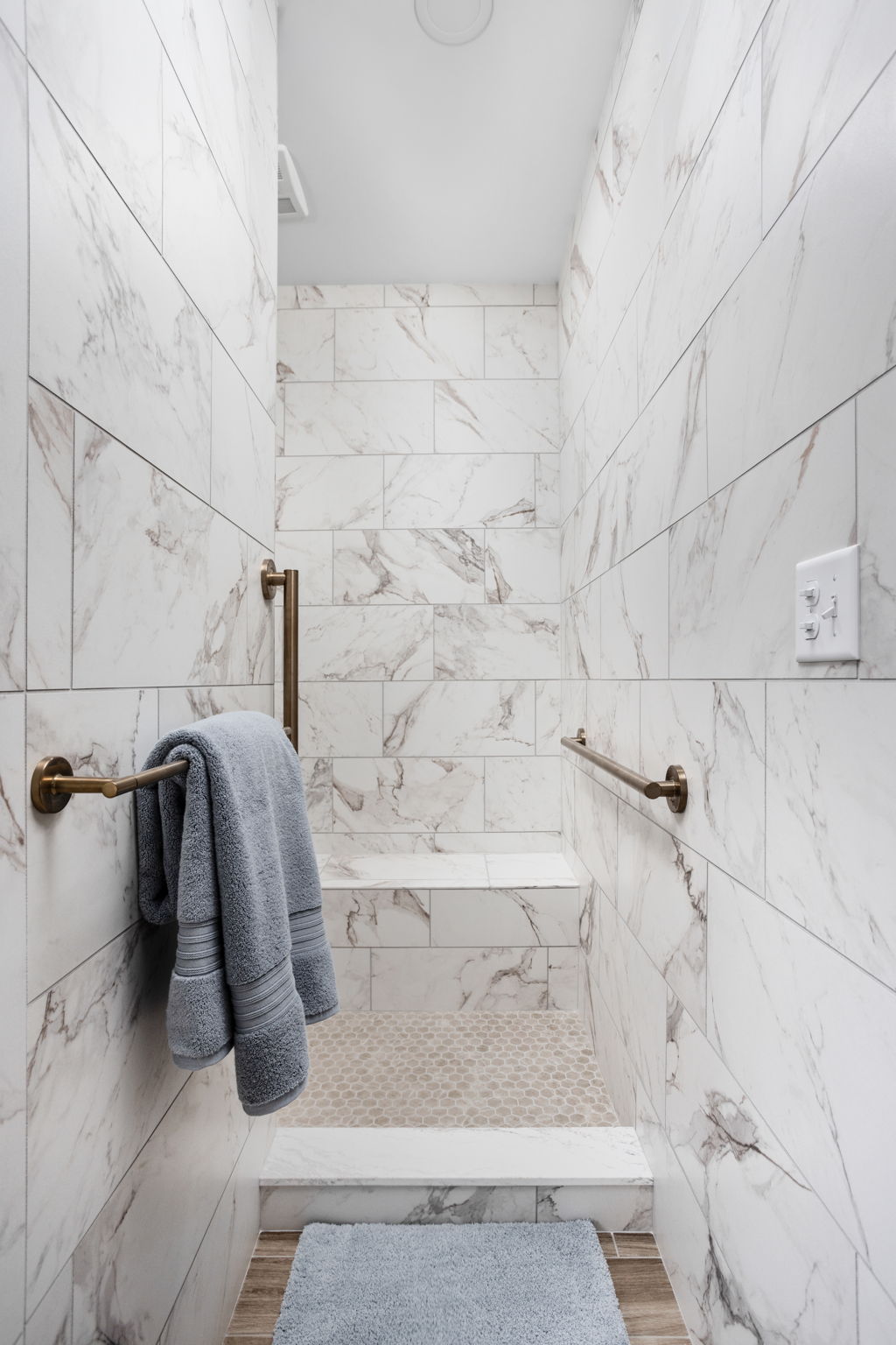 Marble shower with towel hanging on wall hook