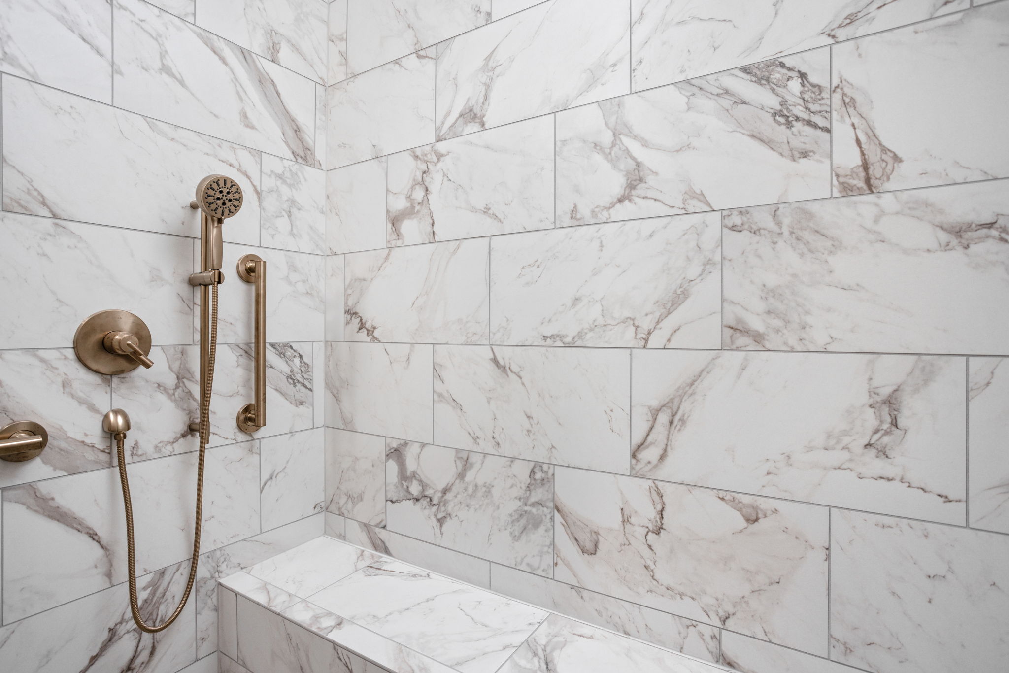 Marble shower wall with brass fixtures