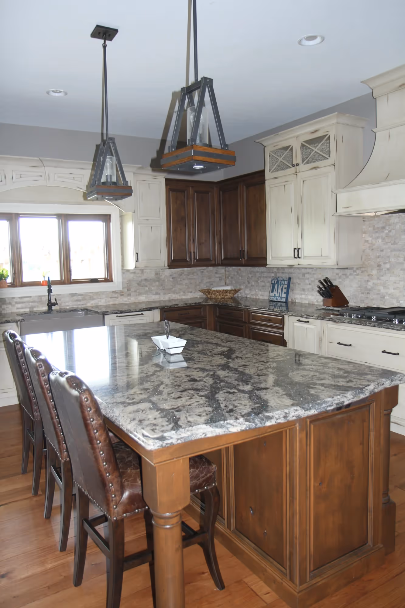 Modern kitchen with white cabinets, wooden island, and bar stools.