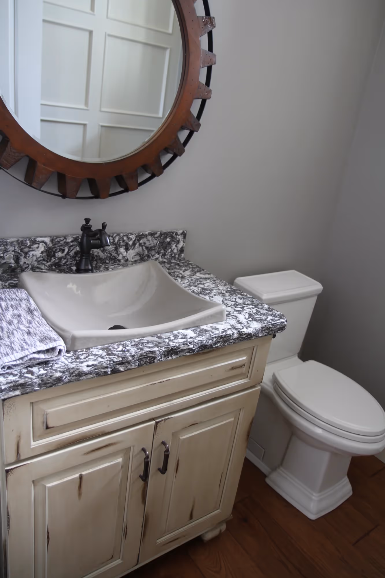 Bathroom vanity with round mirror and white sink