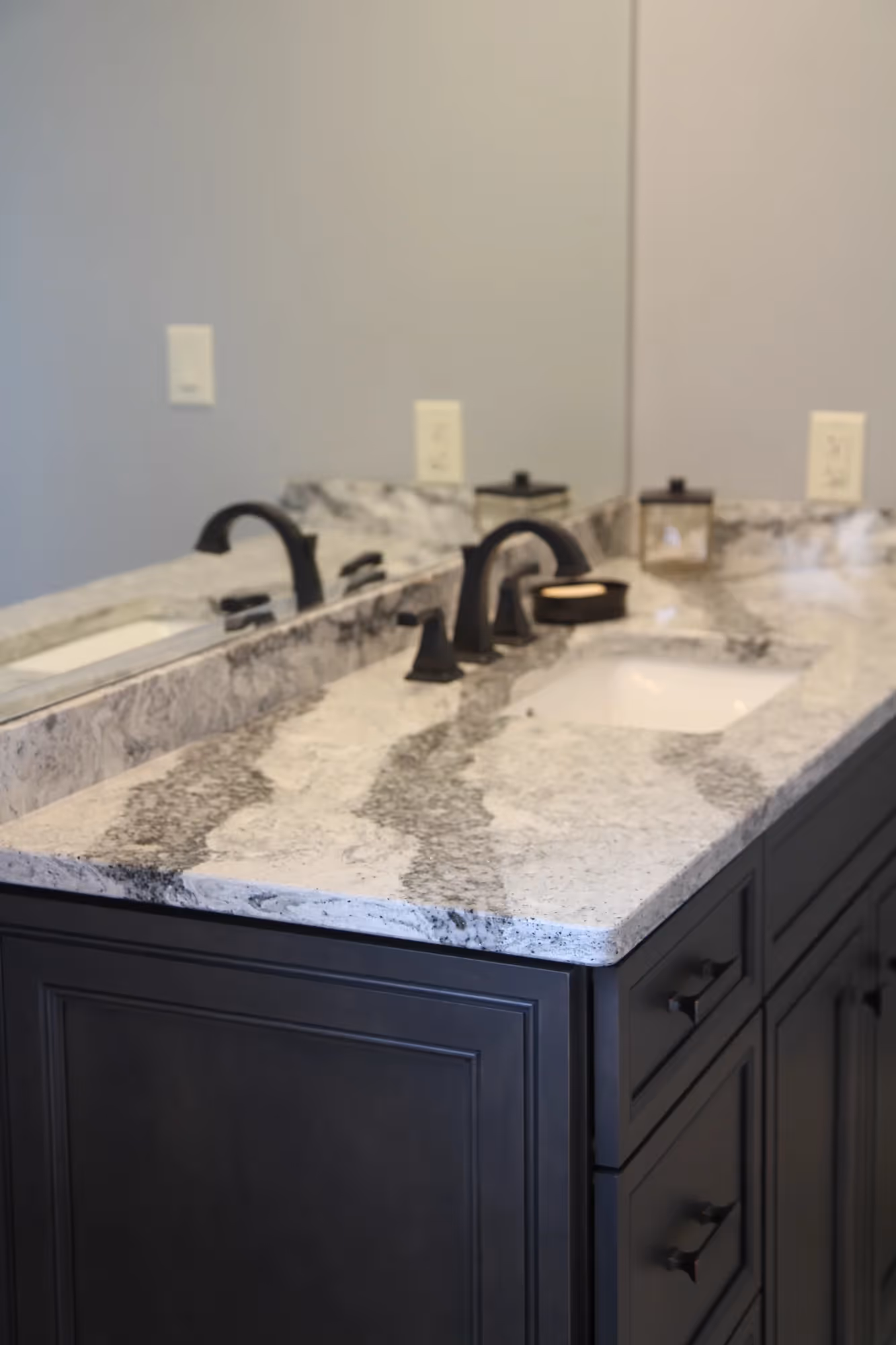 Bathroom vanity with dual sinks and dark cabinets.