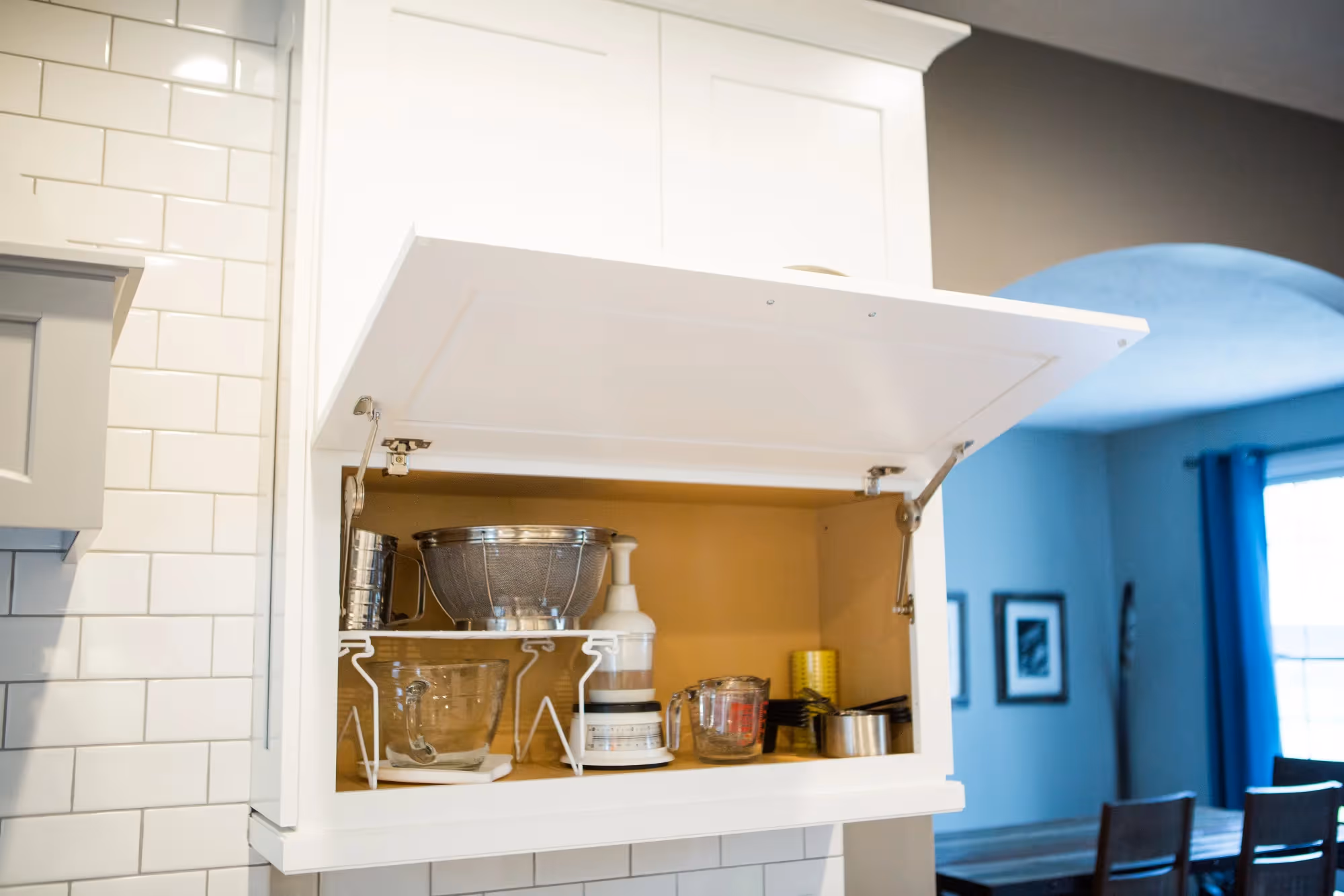 Kitchen pass-through with shelves to blue dining room