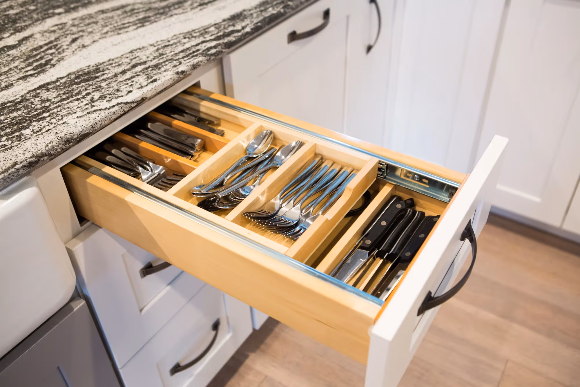 Kitchen drawer pulled open with trash bins