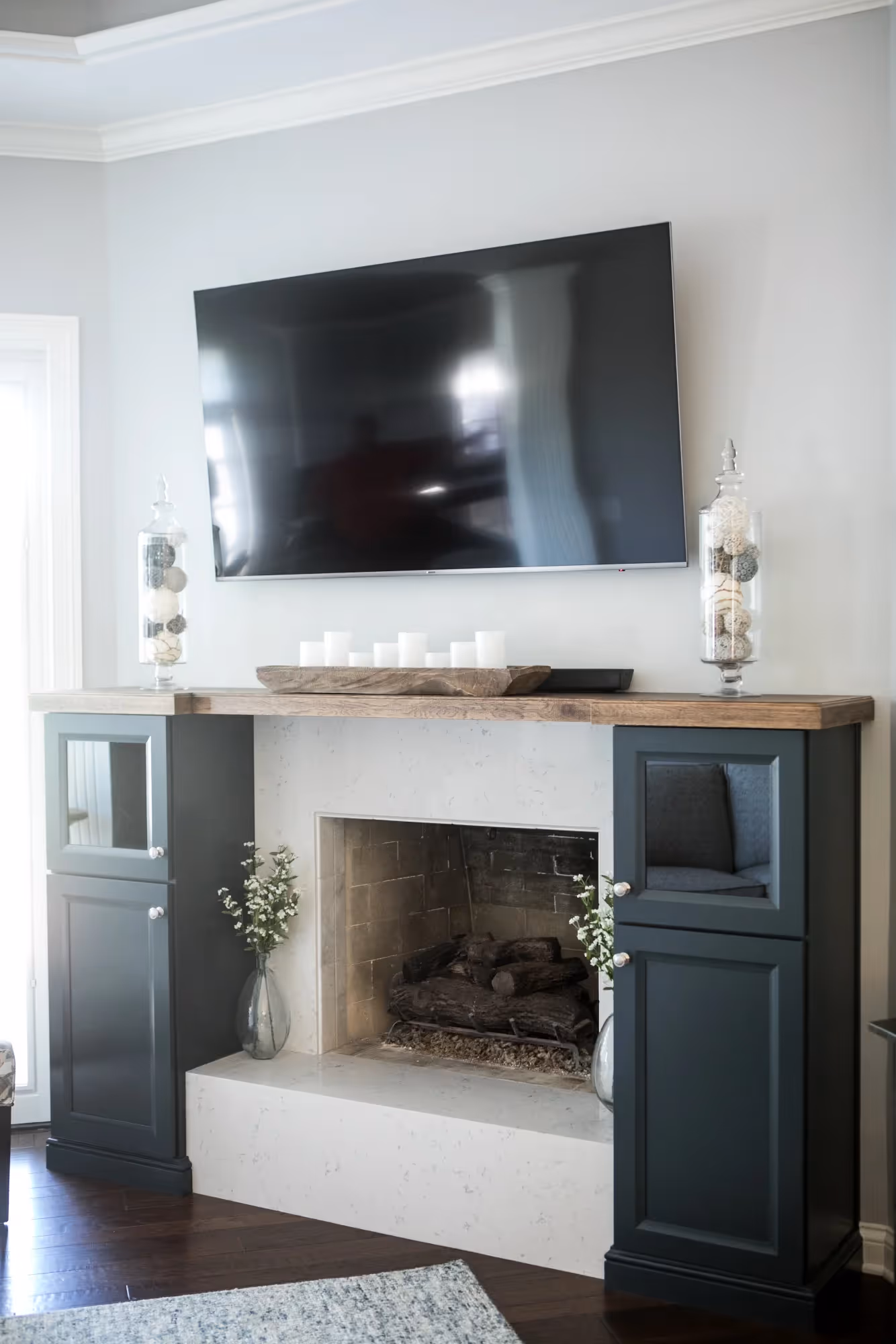 Modern living room with dark built-in shelving and TV area.