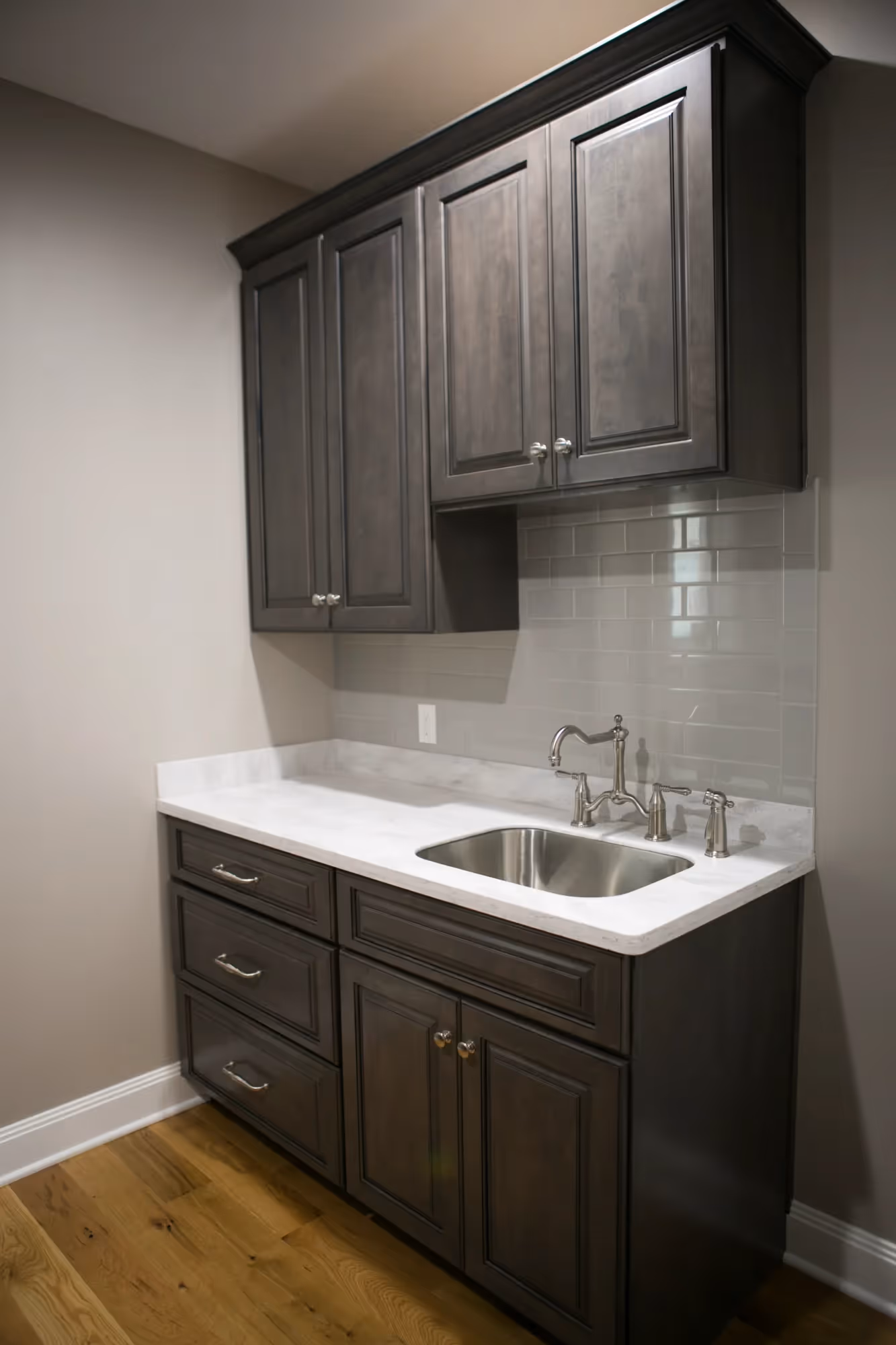 Compact kitchenette with dark cabinetry and sink
