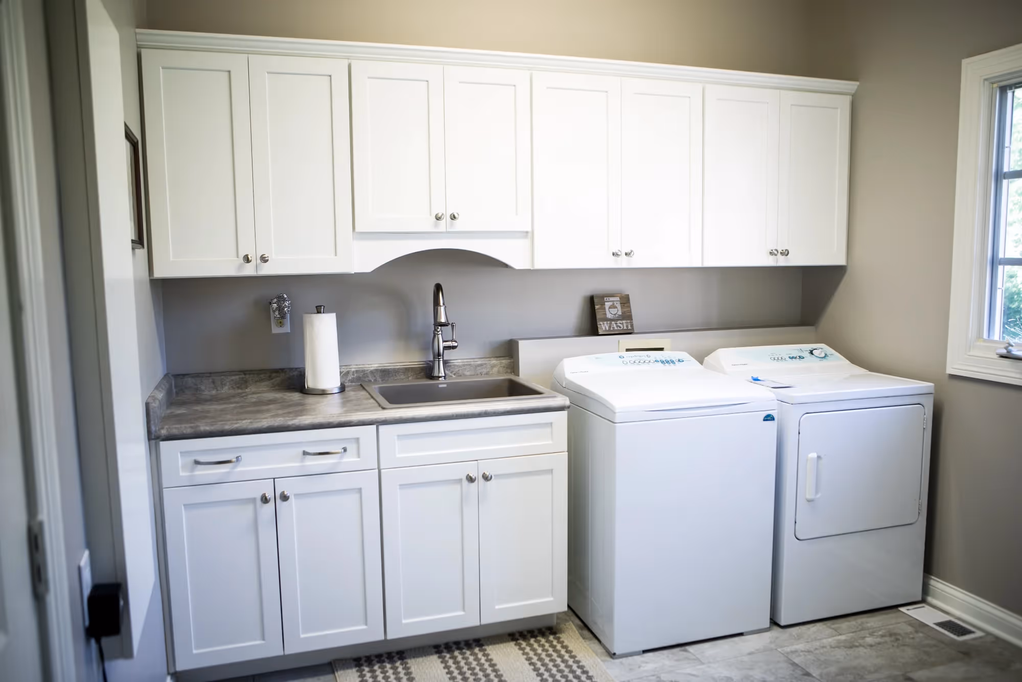 Laundry room with cabinets, sink, and washer and dryer.
