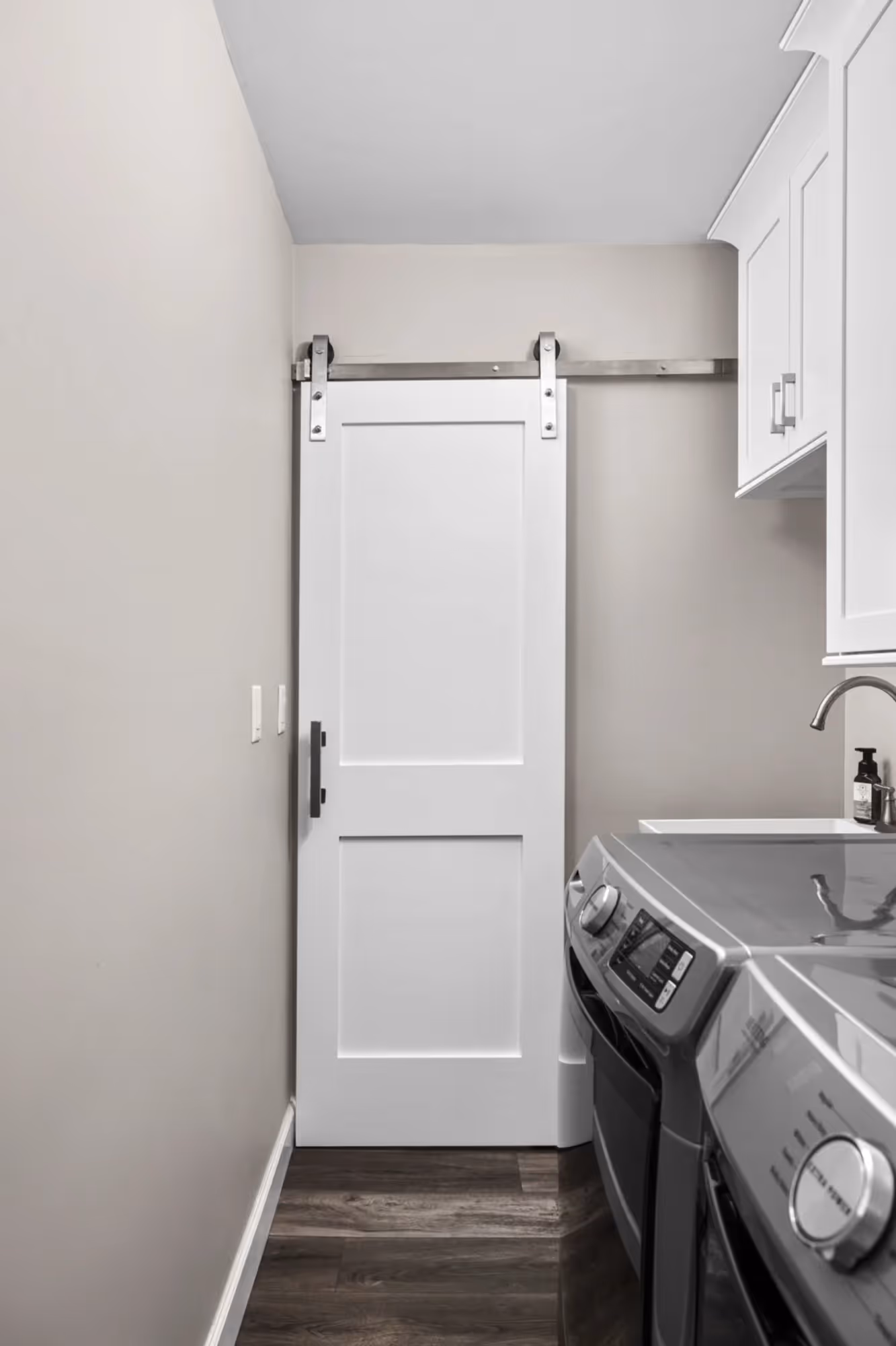 Narrow kitchen with dark cabinets and window