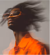 Portrait of a woman with slicked-back hair wearing a black blazer and orange turtleneck, with a double-exposure effect.