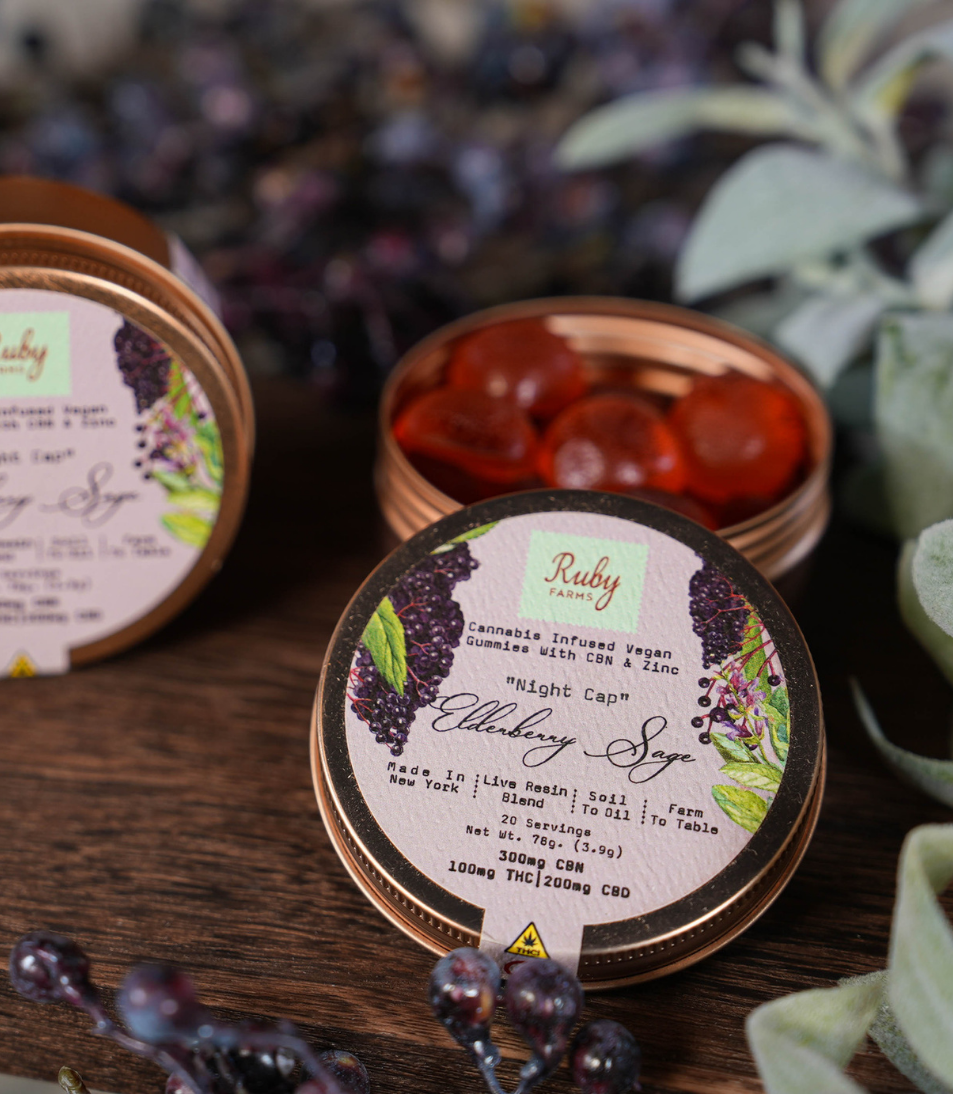 Open tin of Ruby Farms elderberry sage cannabis-infused vegan gummies on a wooden surface.