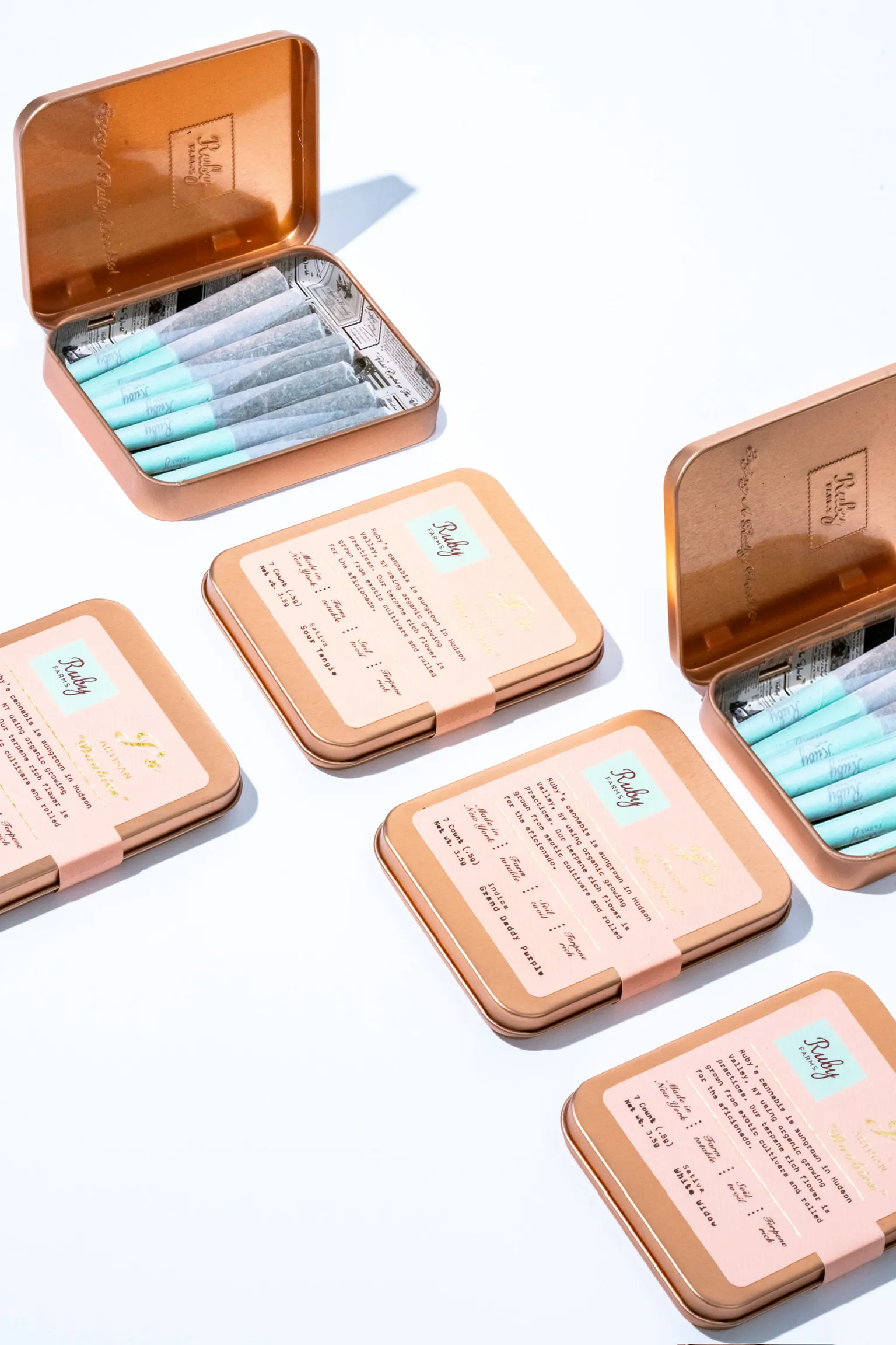 Tin boxes labeled Ruby Farms containing seven pre-rolled cannabis joints each on a white background.