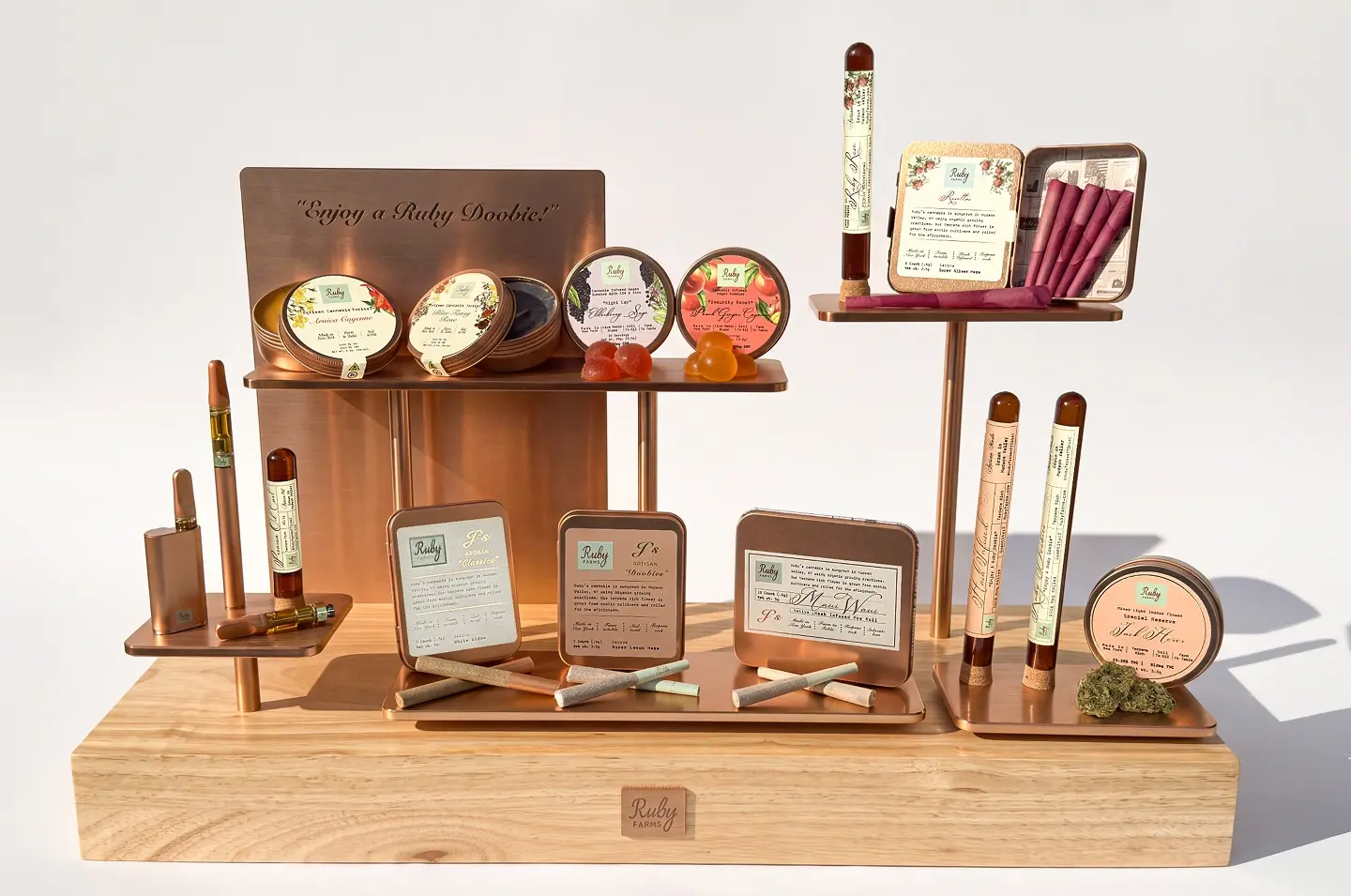 Cannabis-infused vegan mushroom gummies and a vape pen displayed on a wooden table outdoors.