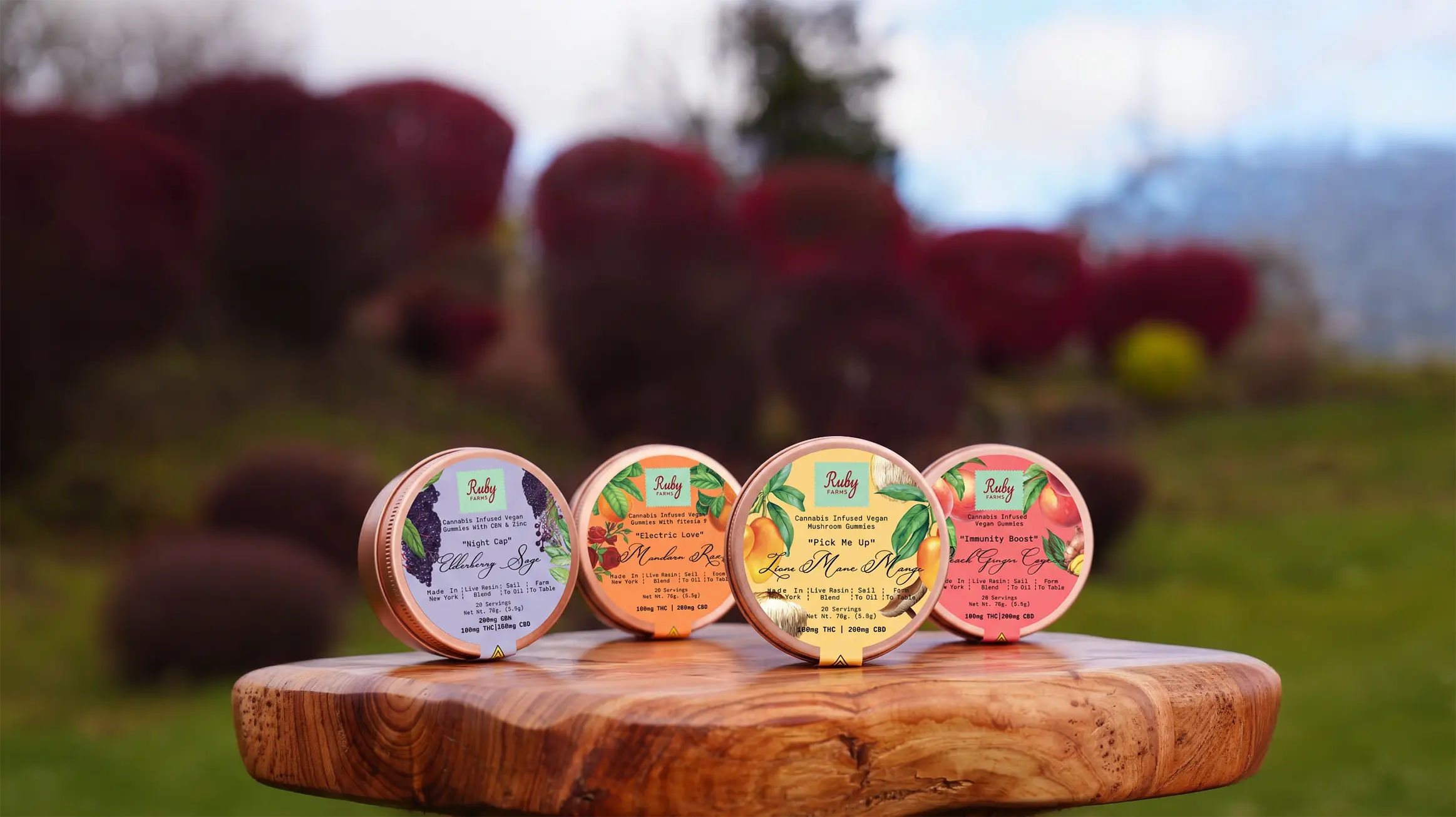 Cannabis-infused vegan mushroom gummies and a vape pen displayed on a wooden table outdoors.