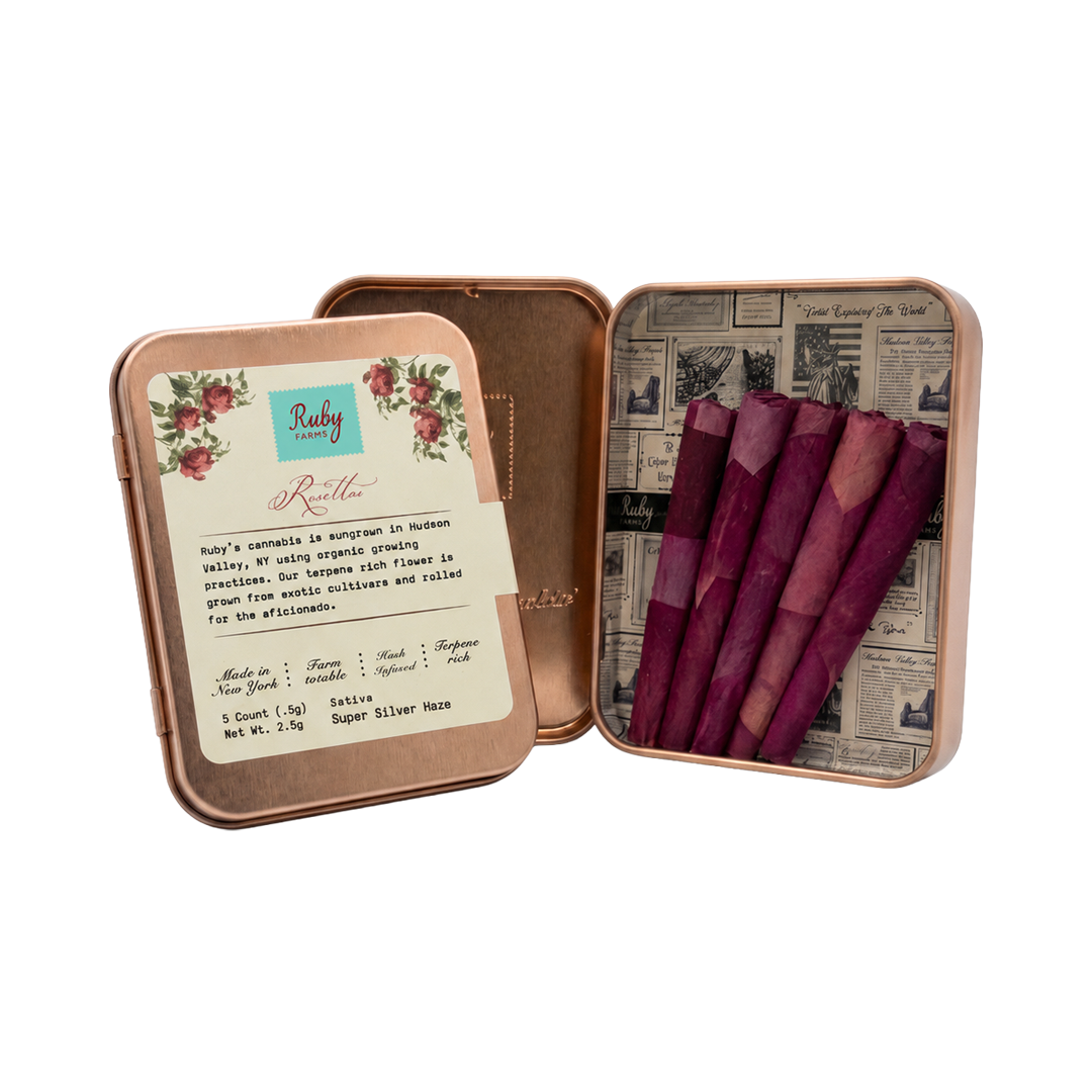 Two pre-rolled joints and a cannabis bud with a labeled glass tube container.
