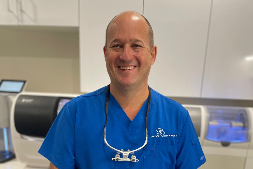 Dr. Bryan Ritchey DDS Houston dentist standing in front of dental technology