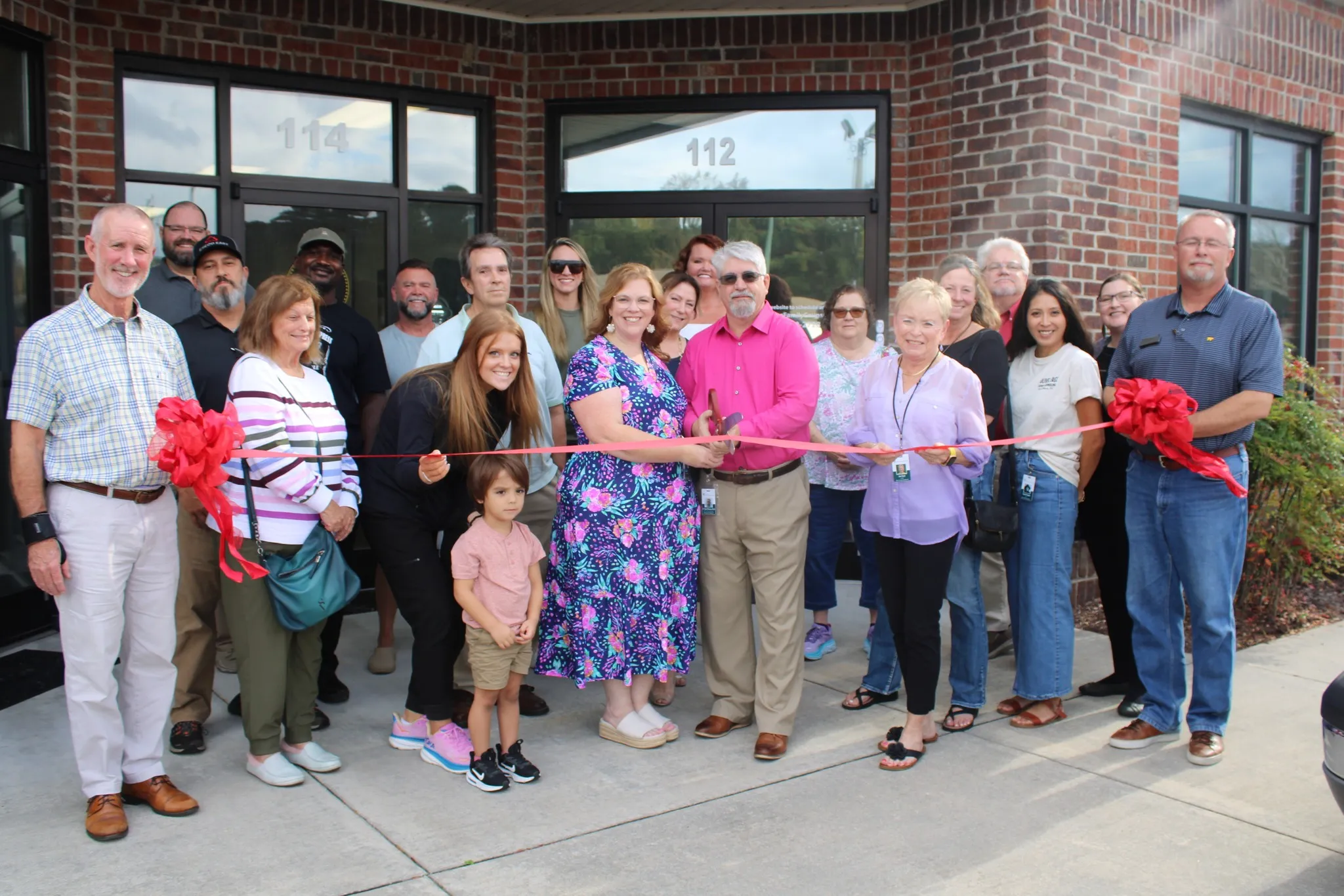 The Olive Tree Family Counseling team celebrating the opening of a new location with a ribbon cutting.
