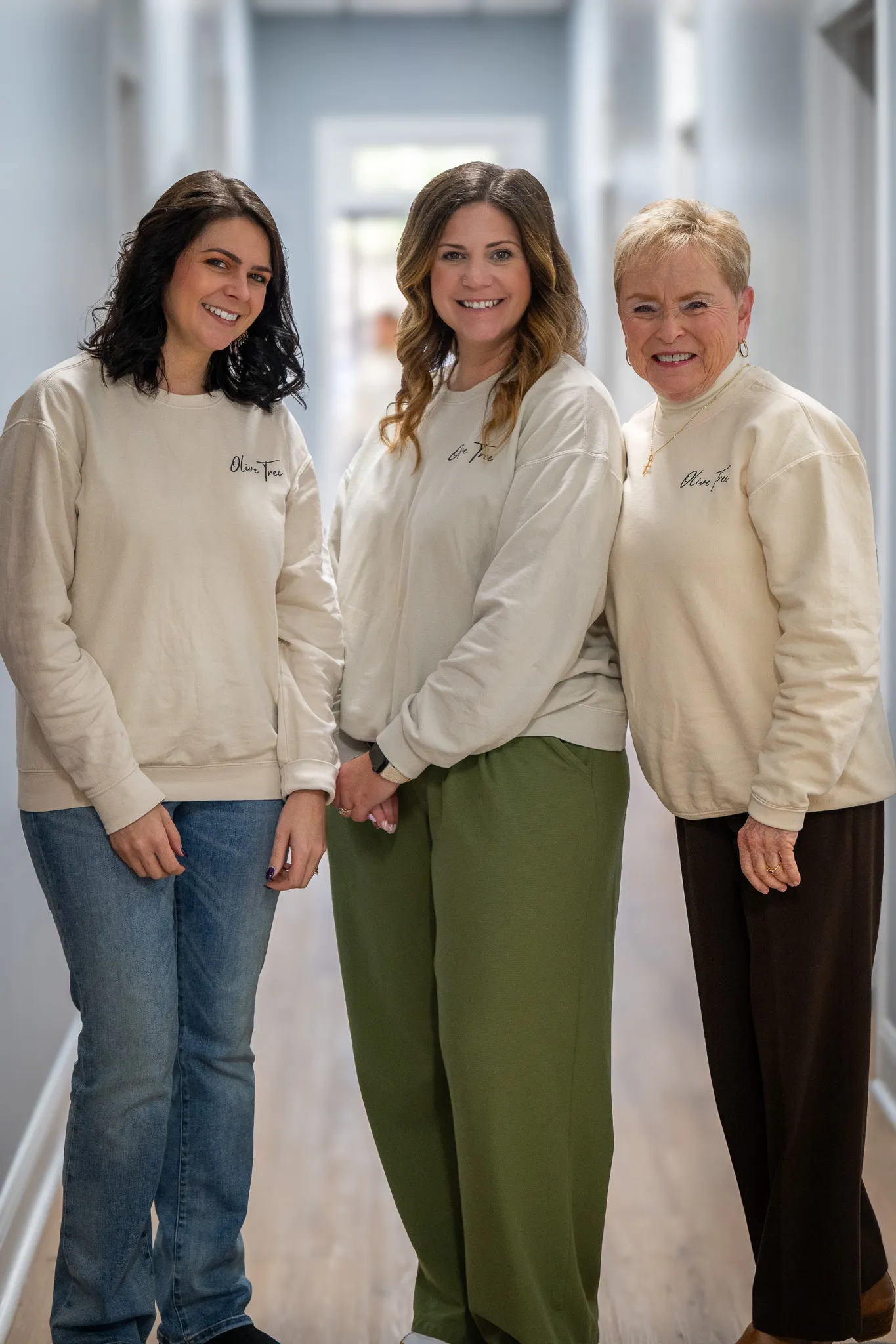 A group of ladies, Jan Hood, Alex Zegers, and Andie Barnett, of Olive Tree Family Counseling standing and smiling