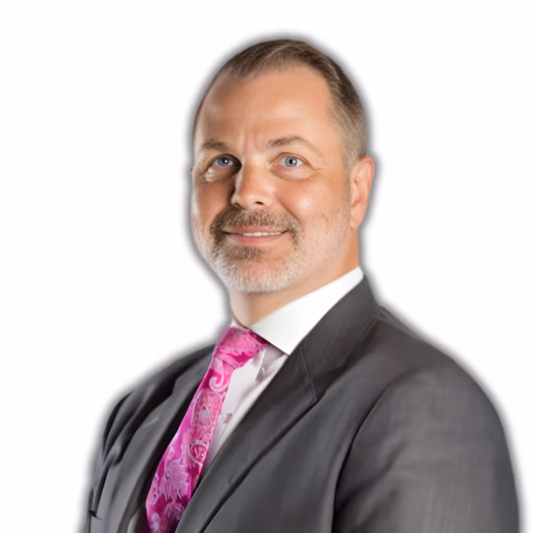 Smiling man with short brown hair and glasses wearing a beige button-up shirt with arms crossed.