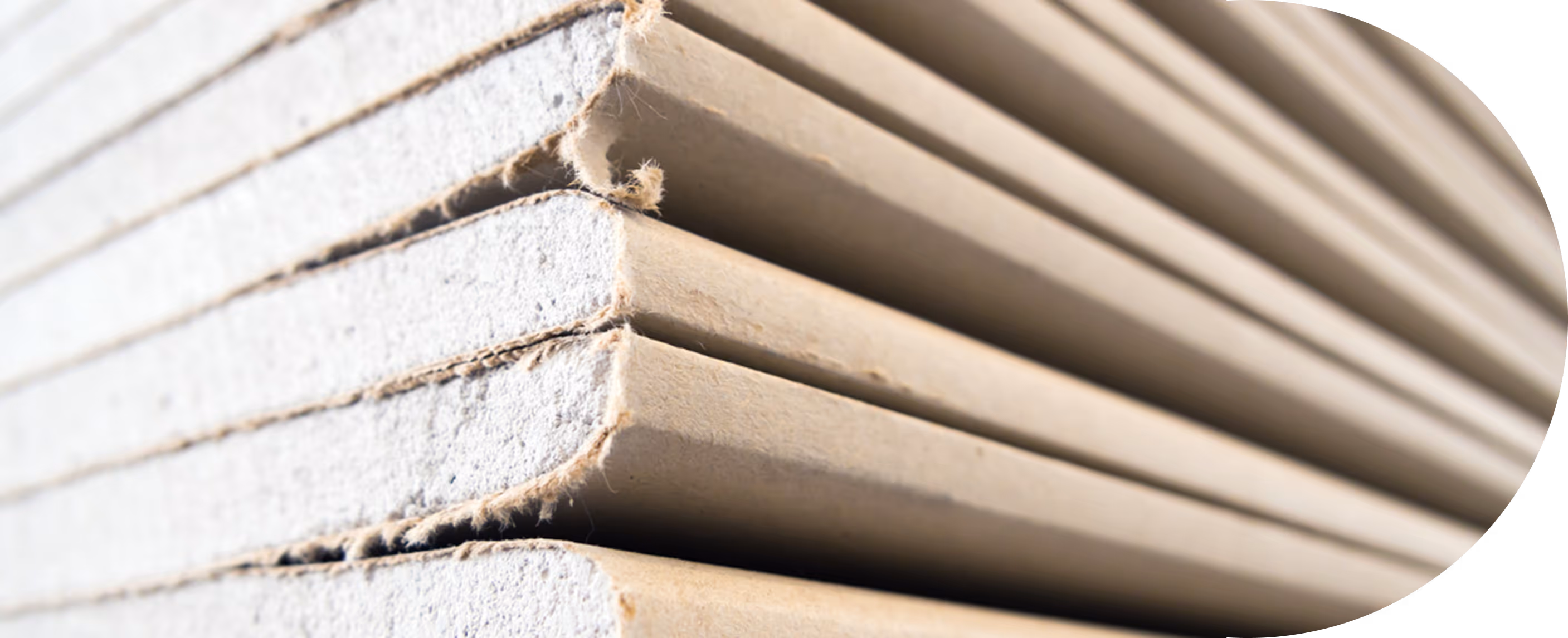 Nahaufnahme eines gestapelten Stapels von hellbraunen Kartonplatten mit rauen Kanten.