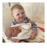 a young girl holding a baby boy