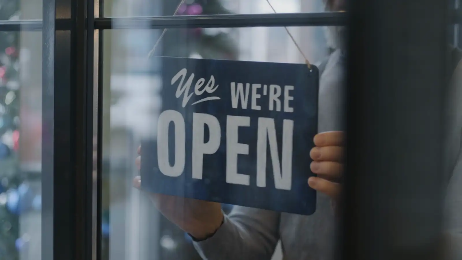 Shop owner opening the door of a small business