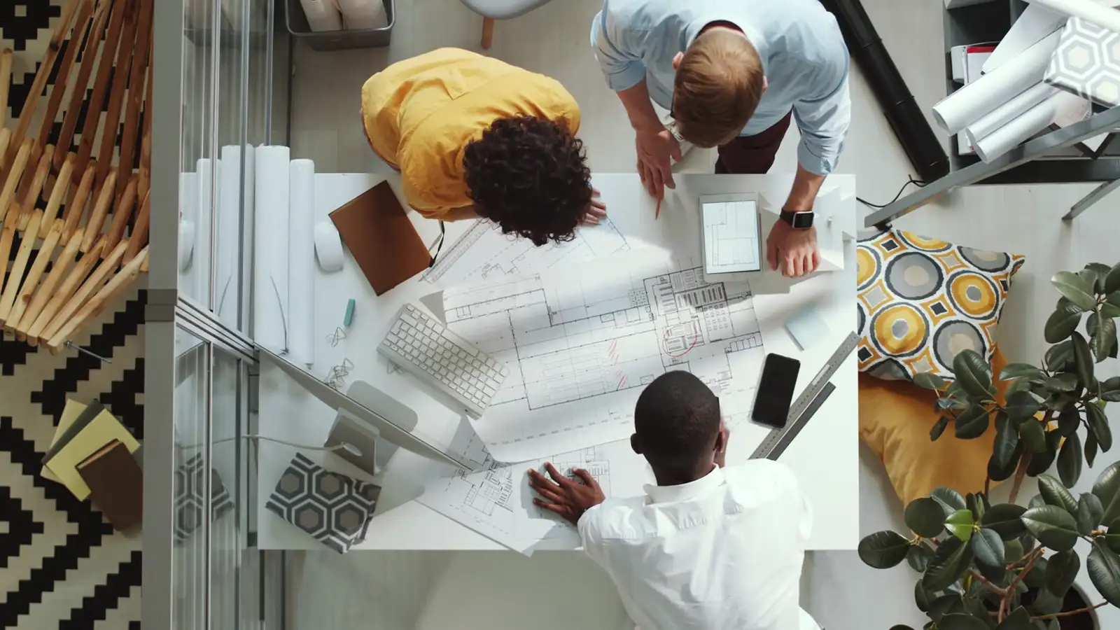 Top-down view of colleagues reviewing plans at a table