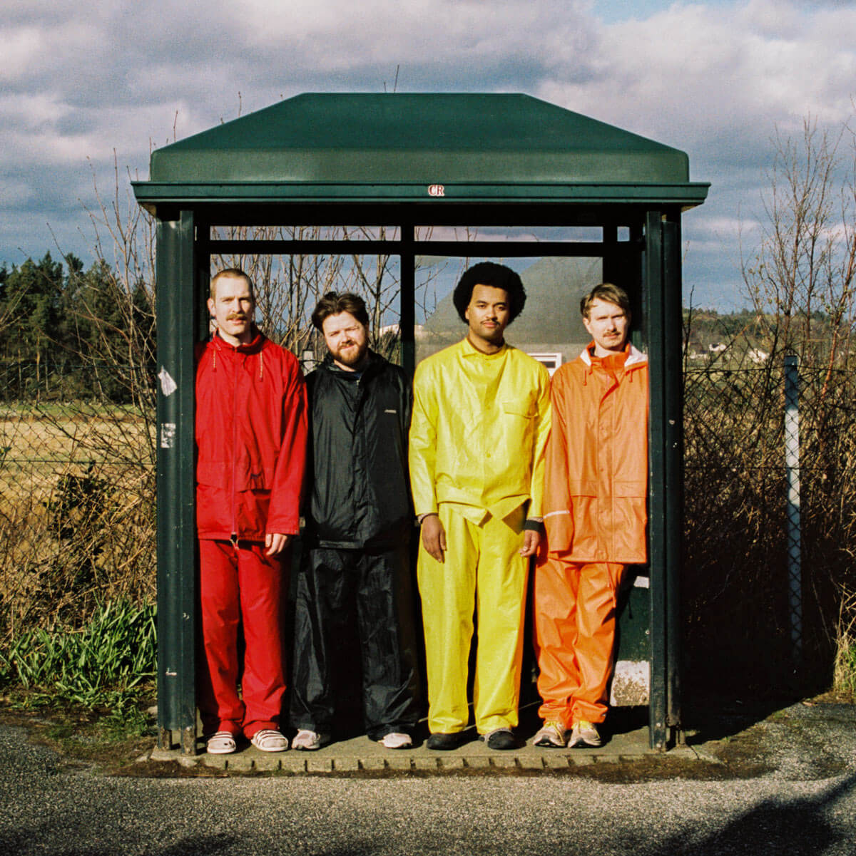 Tøfl band members sitting on a bicycle in a garage.