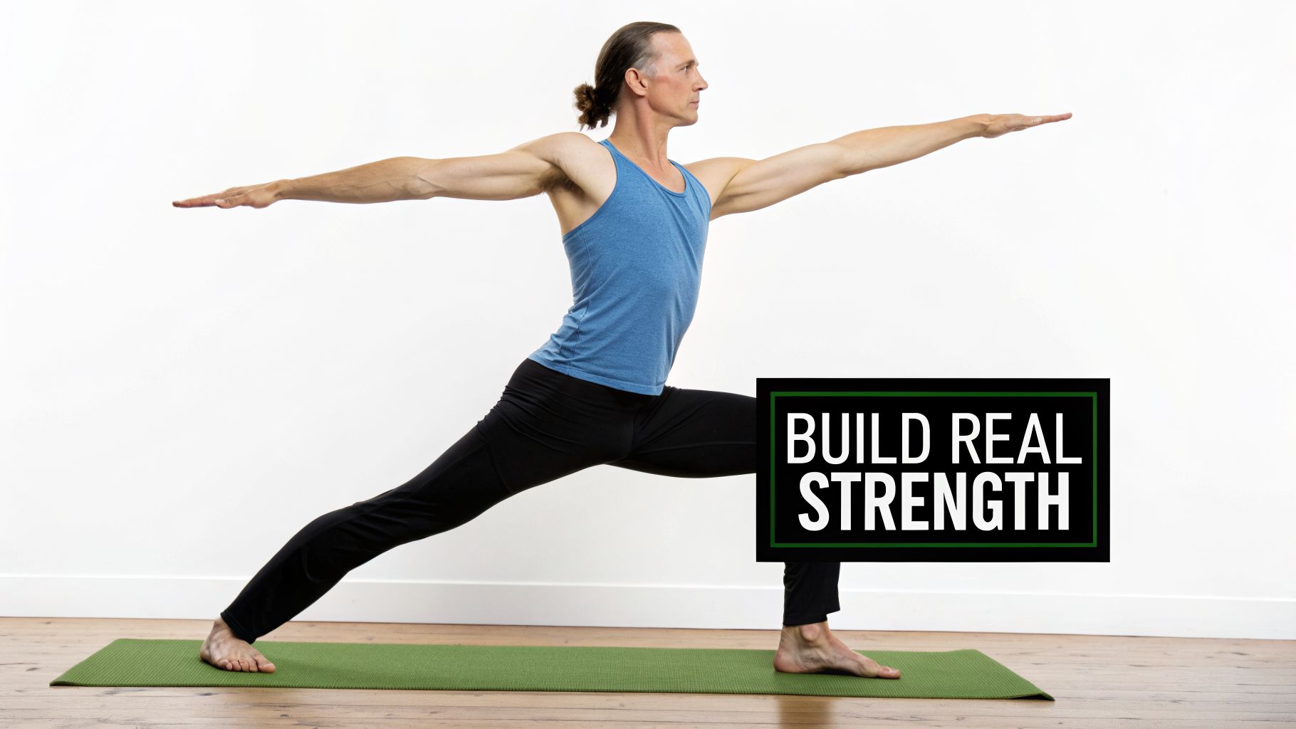 Man in blue tank top doing Warrior II yoga pose on green mat, with 'BUILD REAL STRENGTH' text overlay.