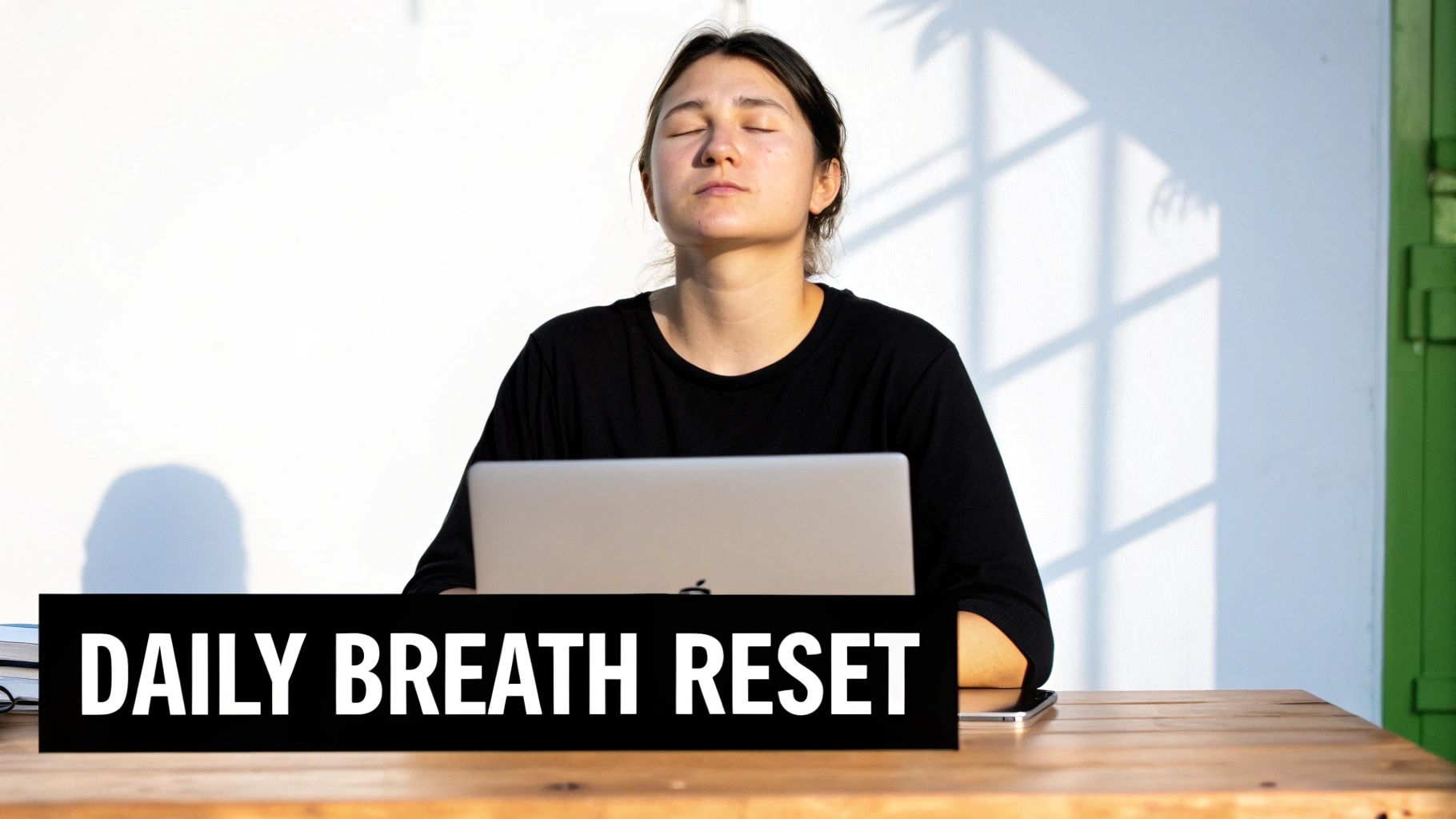 A woman practices a daily breath reset, eyes closed, meditating at a desk with a laptop.