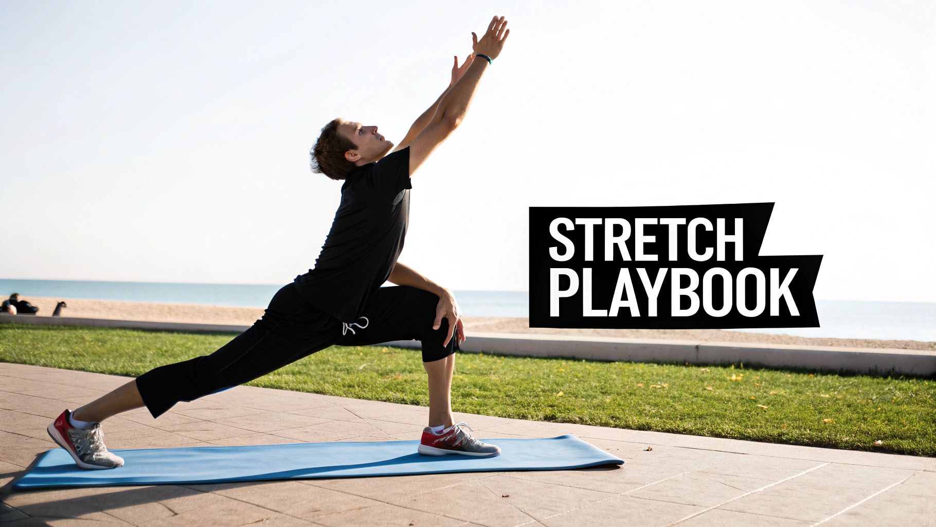 A man in black athletic wear performs an active stretch on a blue mat outdoors by the ocean.
