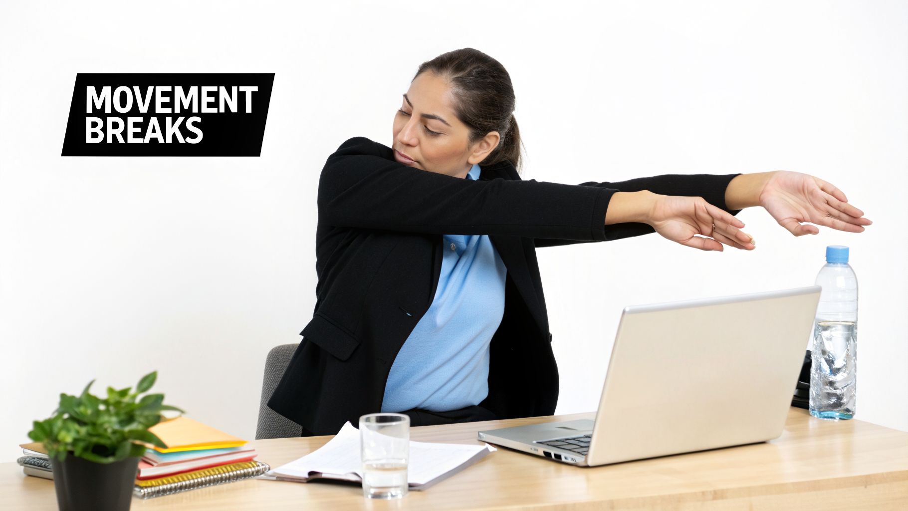 A woman in office attire stretches her arms and wrists at a desk, promoting movement breaks.