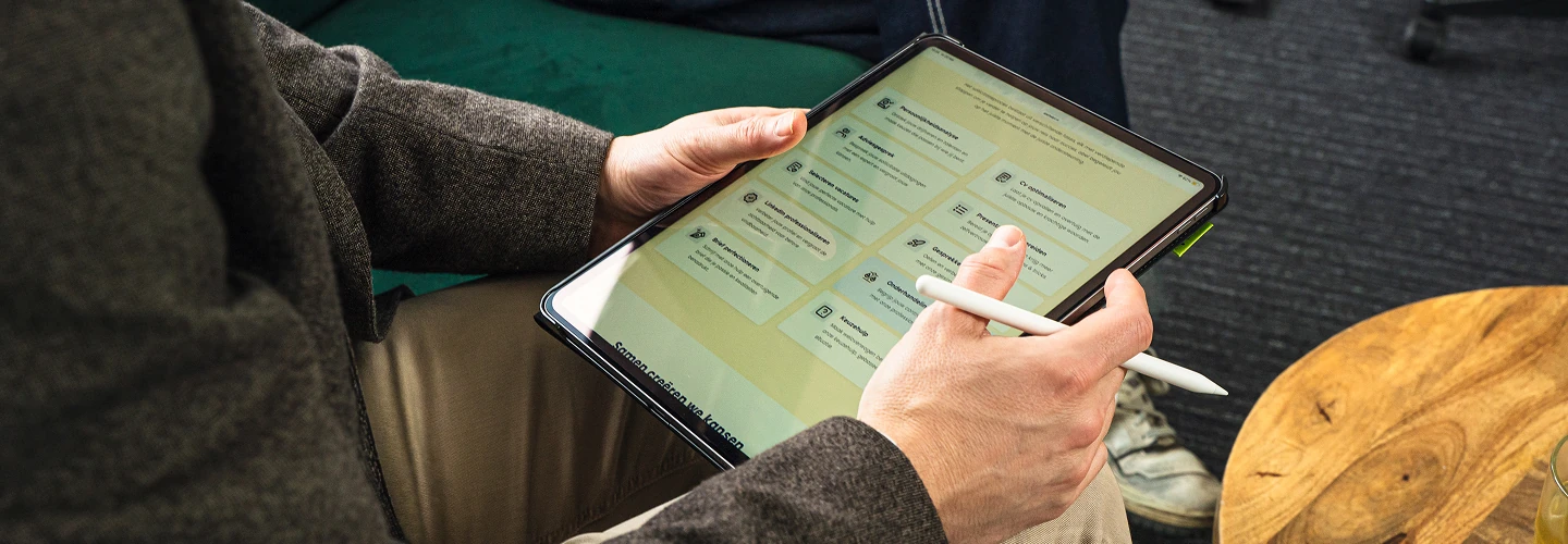 Persoon die een tablet vasthoudt en een stylus gebruikt om een overzicht van verschillende diensten op het scherm te bekijken.