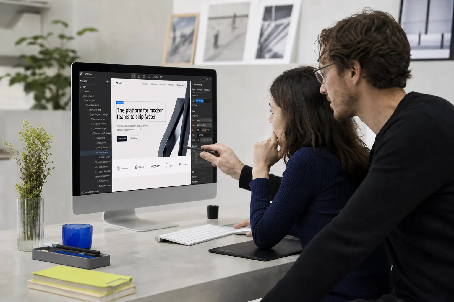Deux personnes revoient la maquette d'un site dans le Designer Webflow, sur un grand écran