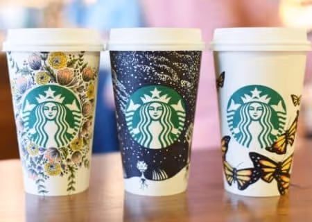 Three Starbucks' cups with hand-drawn illustrations for white cup UGC campaign