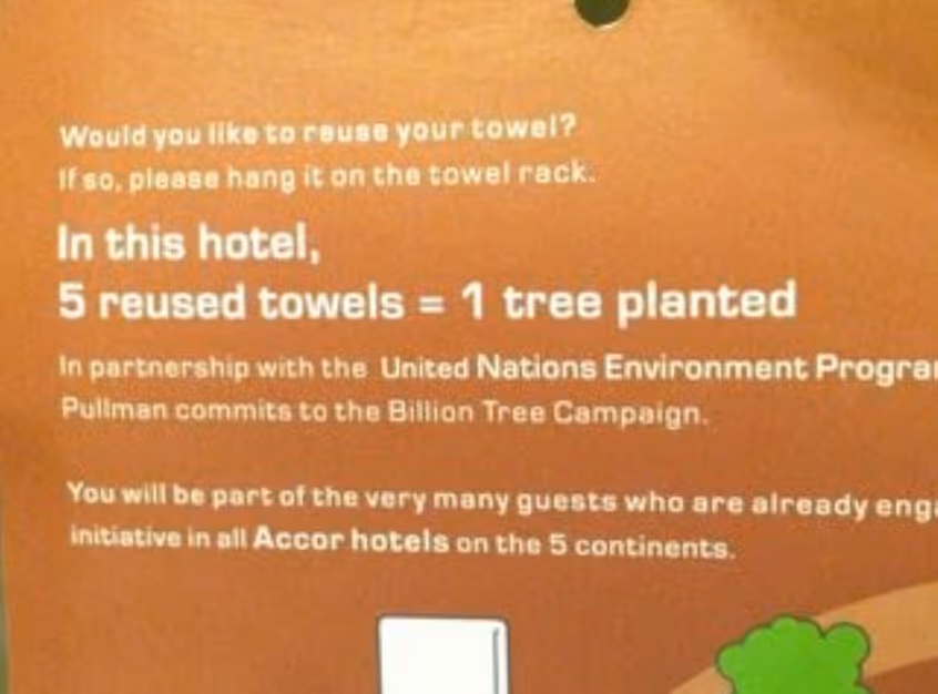 A hotel sign that says 5 reused towels = 1 tree planted via a partnership between United Nations Environment Program and Accor Hotels